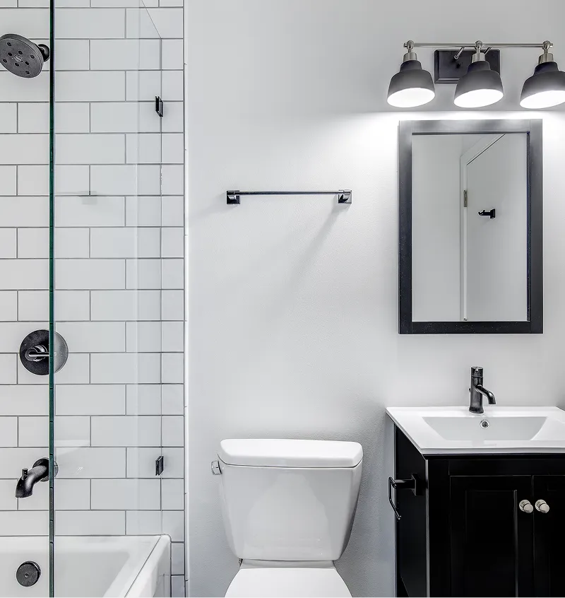 Updated black and white bathroom featuring subway tile shower and modern vanity.