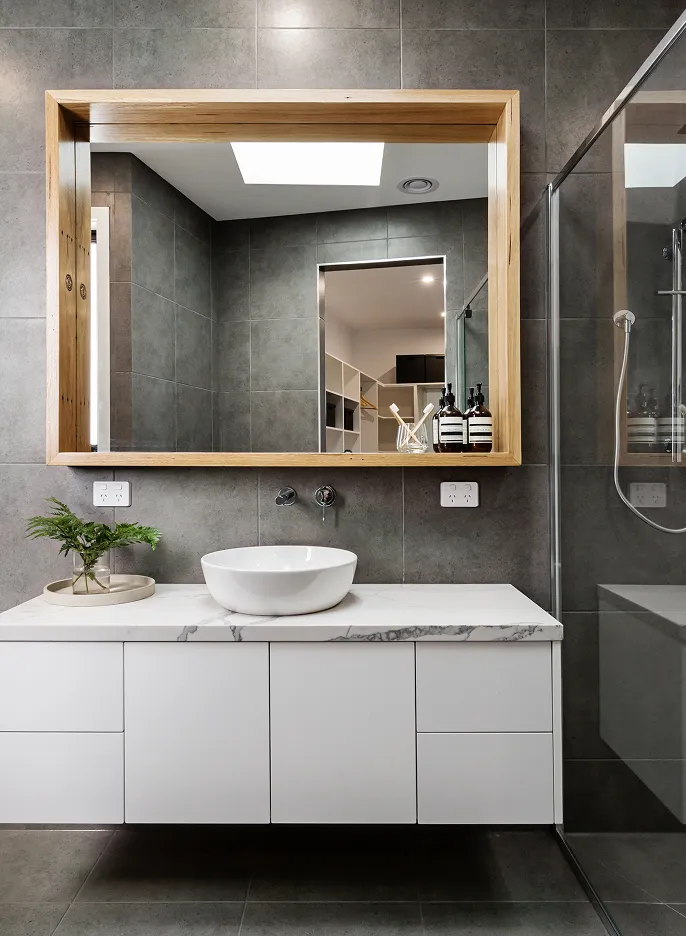 Contemporary bathroom renovation with floating vanity, vessel sink, and wood-framed mirror.