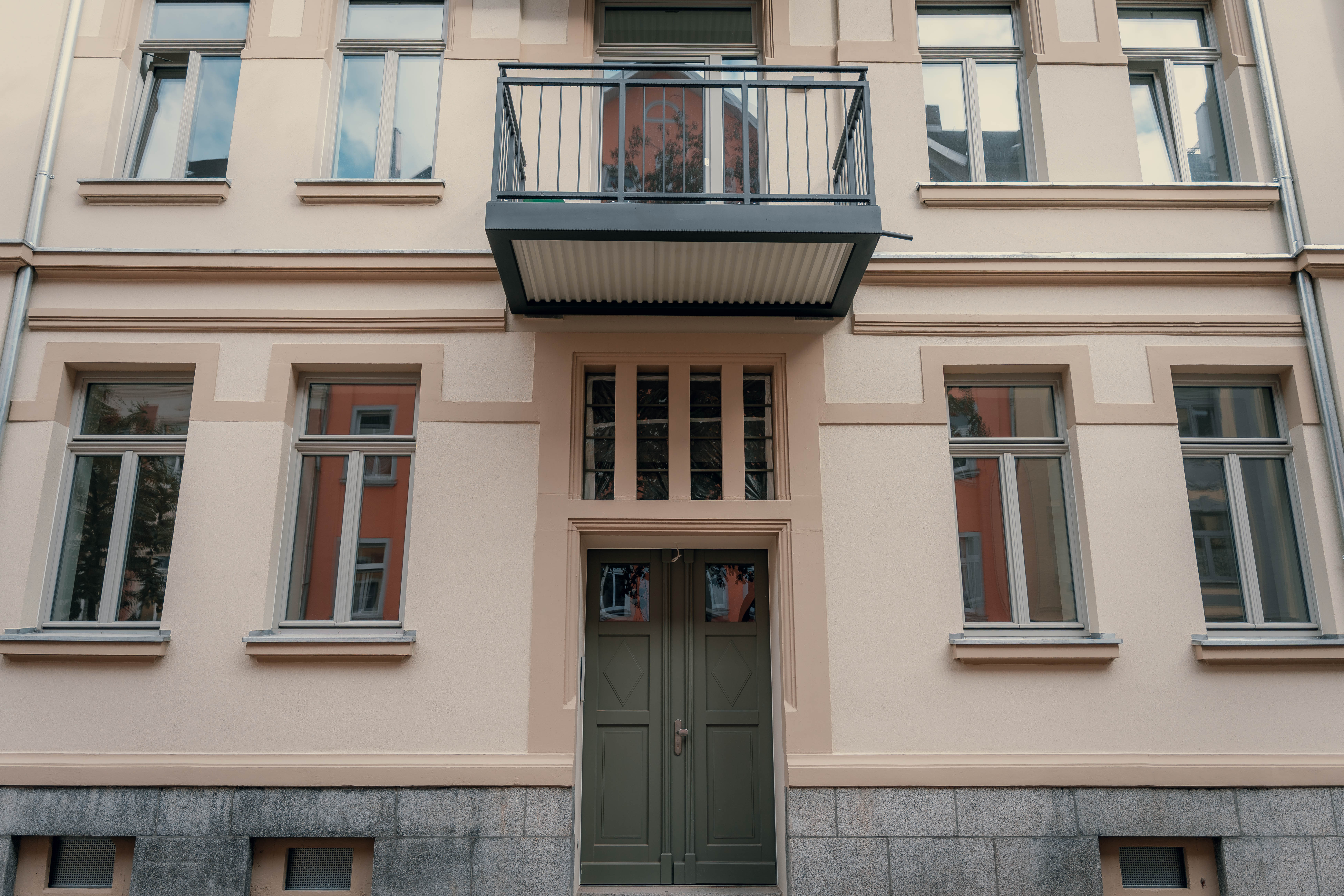 Komplett sanierte Fassade eines Altbaus mit neuem Außenputz und Anstrich im Vogtland.