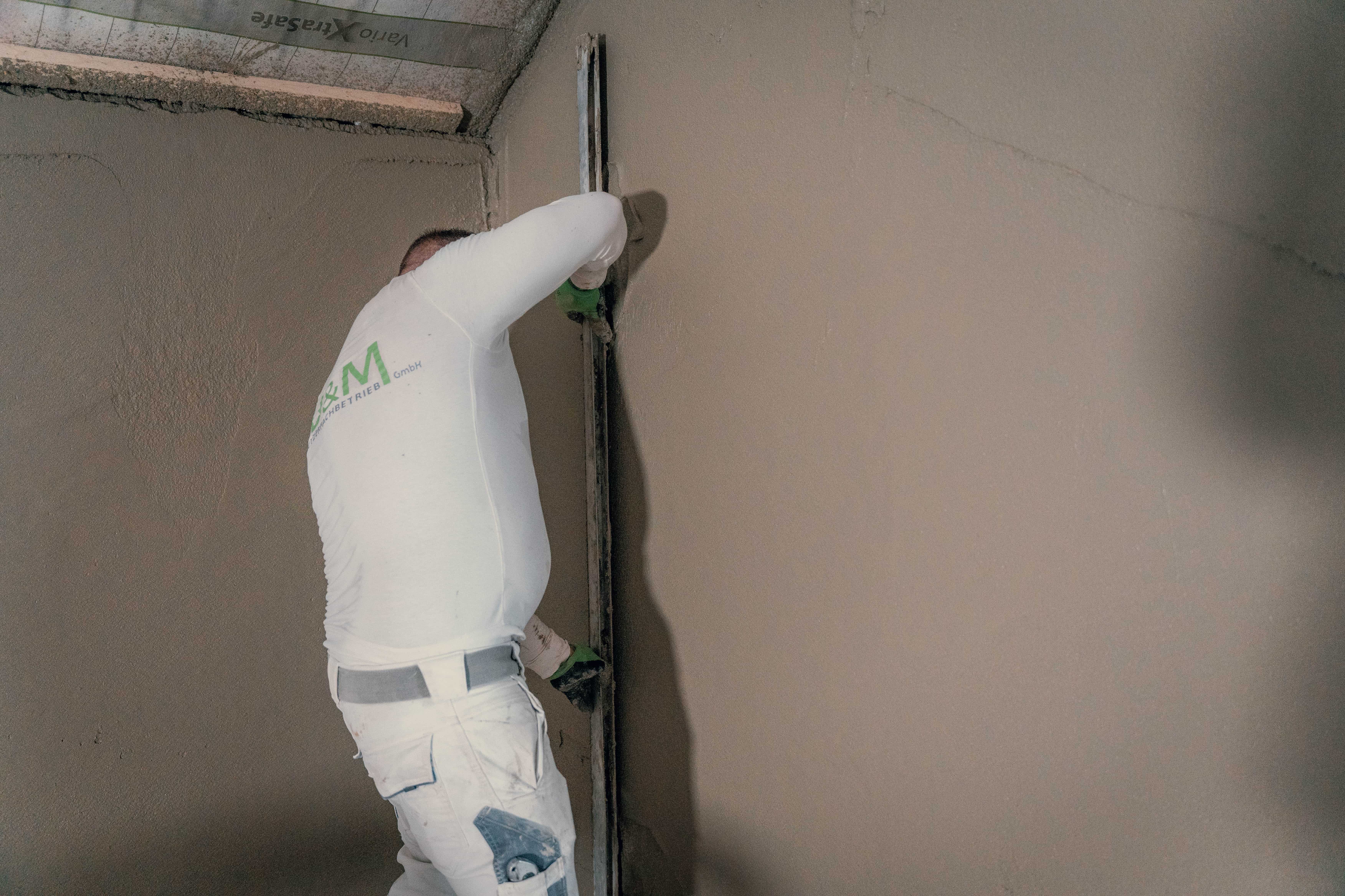 Fachhandwerker von UM Putzerfachbetrieb beim fachgerechten Abziehen und Glätten einer Wand im Vogtland.