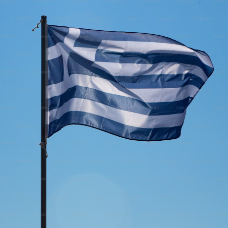 Griechische Flagge mit horizontalen blauen und weißen Streifen weht vor klarem blauem Himmel.