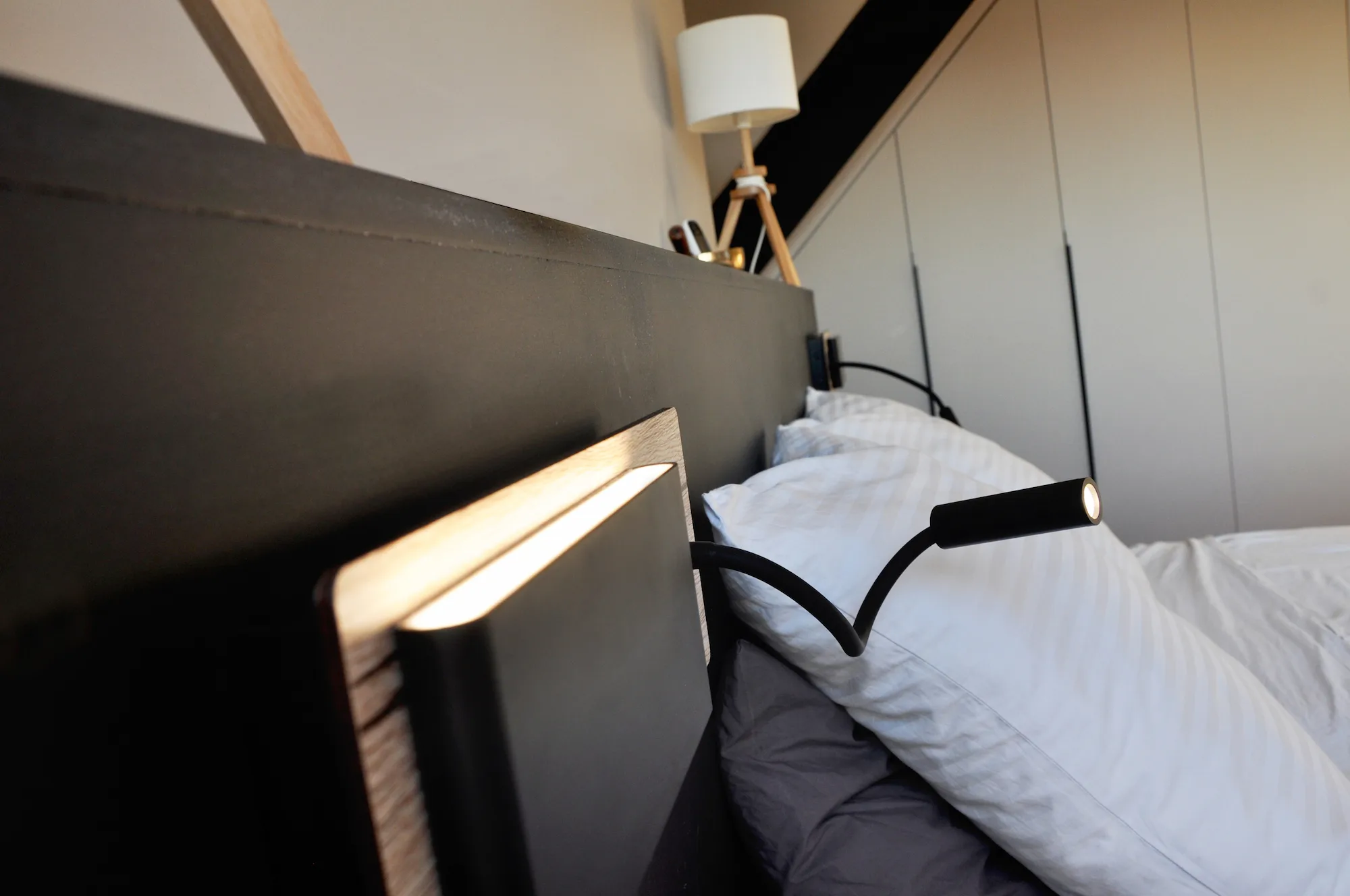 Tête de lit moderne avec éclairage intégré pour un espace nuit fonctionnel.