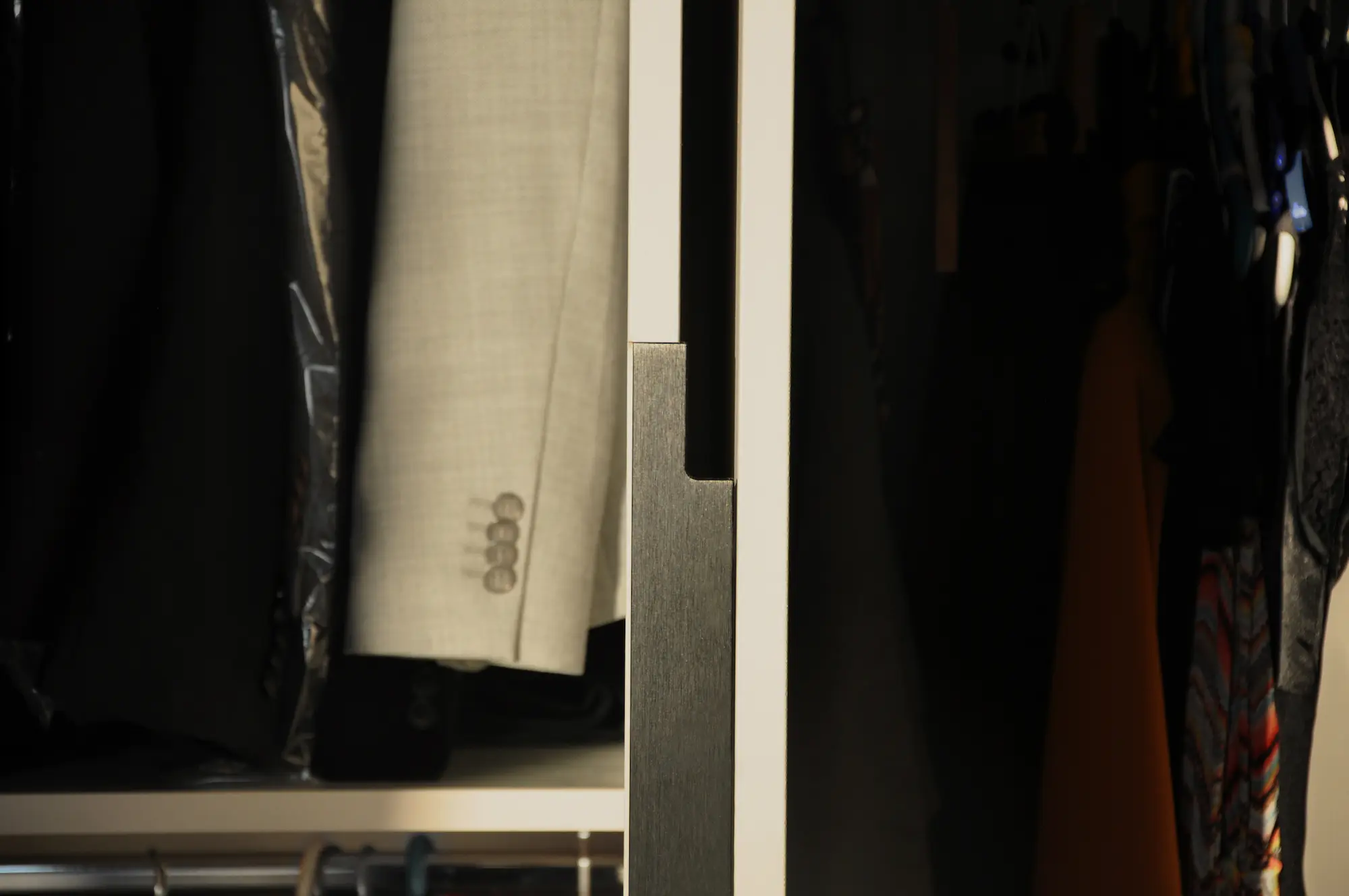 Détail d'un dressing contemporain avec penderie intégrée et rangement sur-mesure