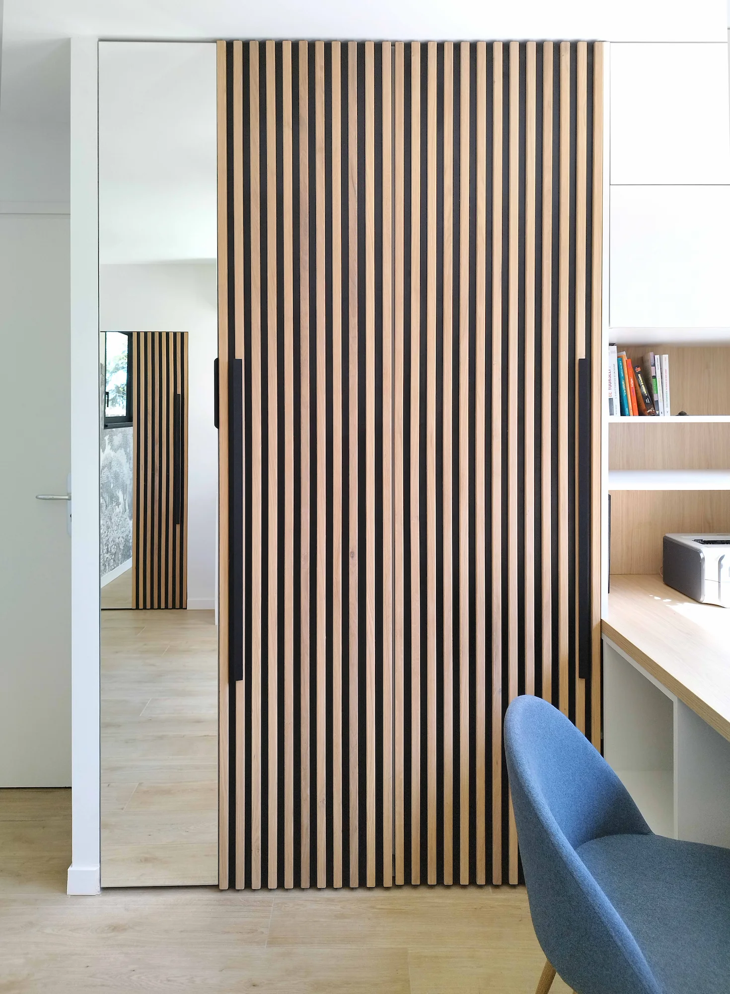 Élément de séparation en bois ajouré dans une zone bureau.