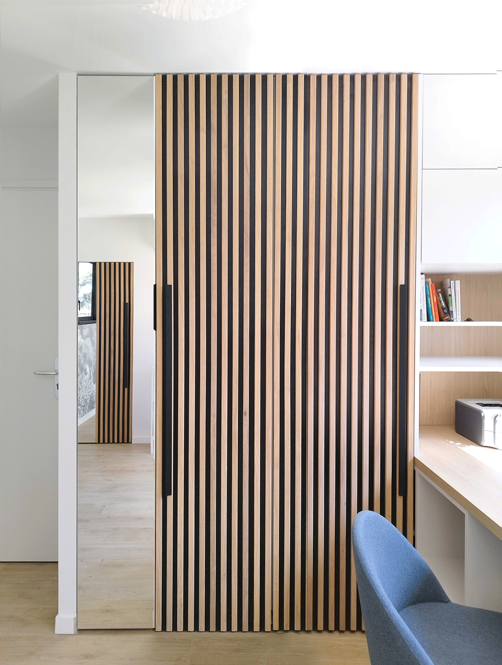 Rangement ouvert avec structure miroir et façade bois, élément sur mesure réalisé par Jiwa.A dans l’extension.