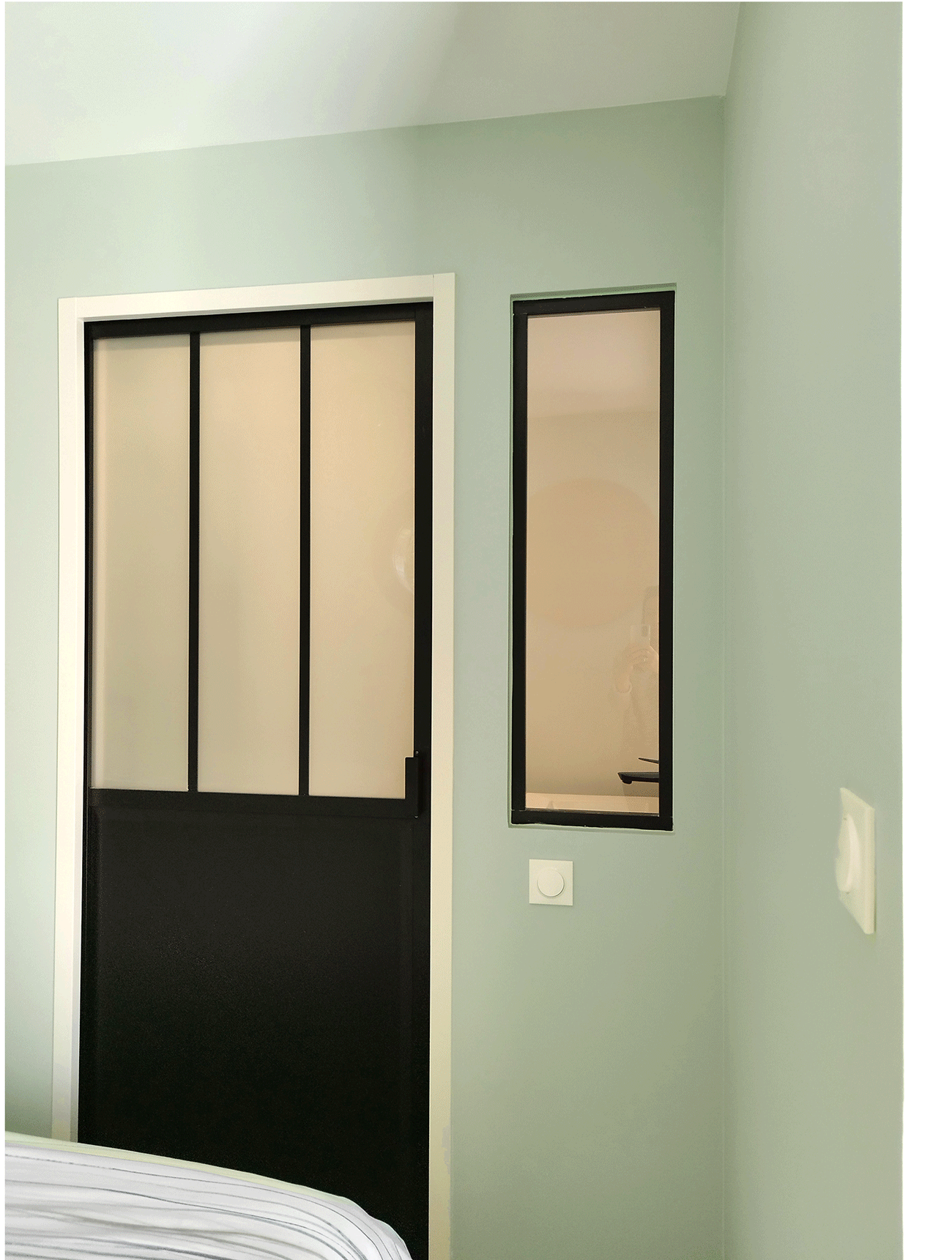 Accès à la salle d’eau par une porte vitrée noire, détail architectural imaginé par Valentine Bourdier.