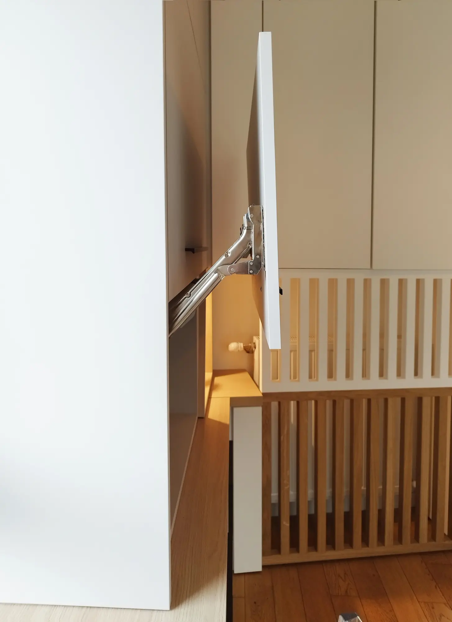 Support TV escamotable intégré au meuble sur mesure.