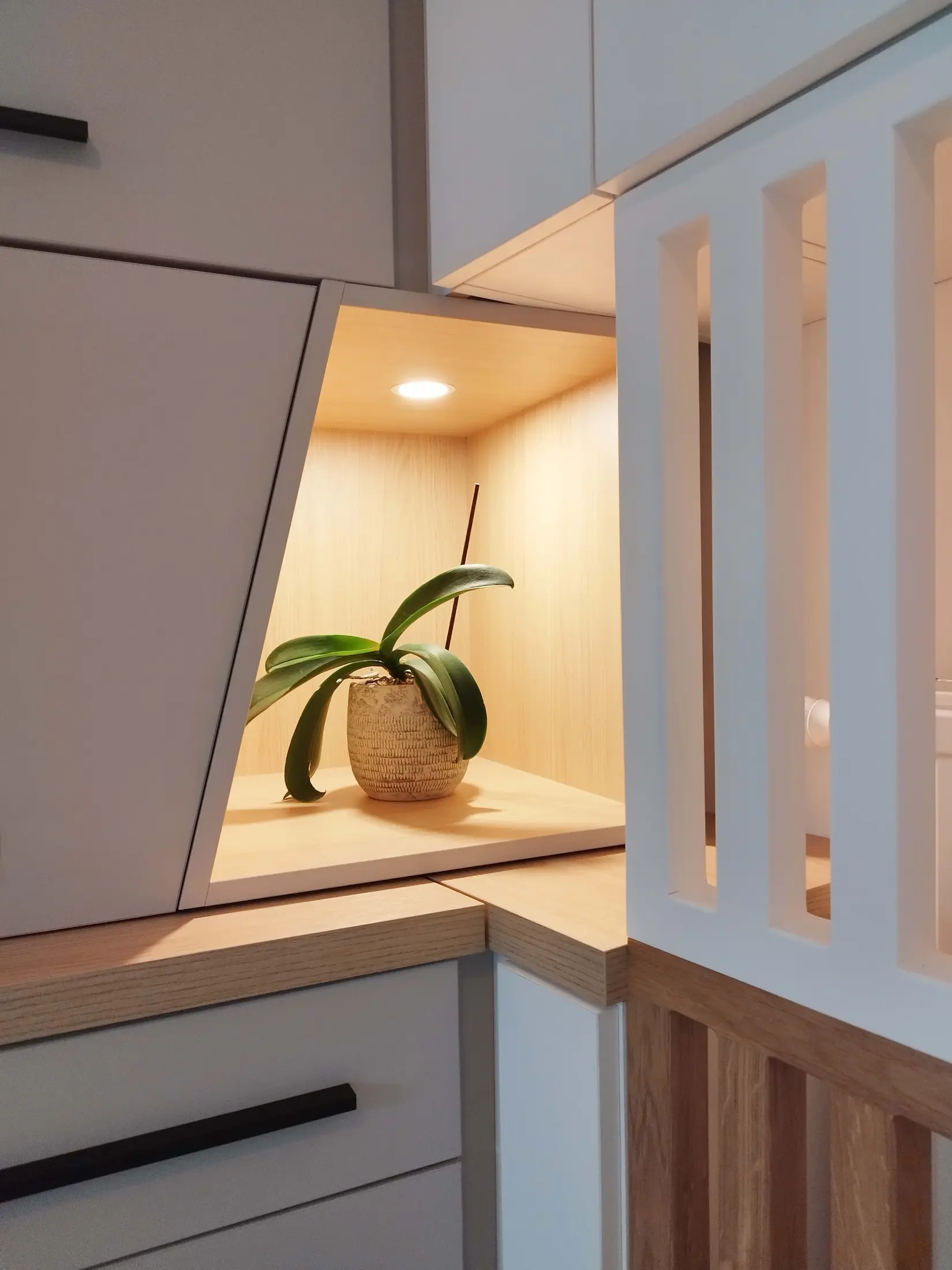 Niche décorative en bois éclairée, intégrée au mobilier sur mesure.