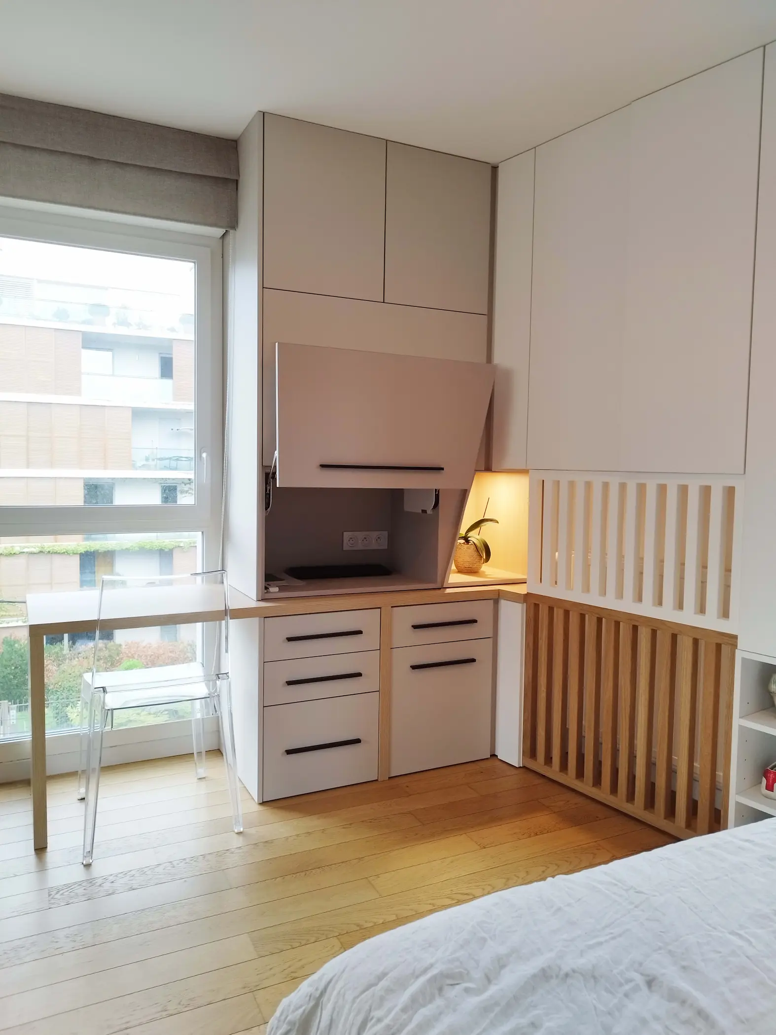 Porte relevable du meuble sur mesure révélant l’espace technique conçu par Jiwa.A.