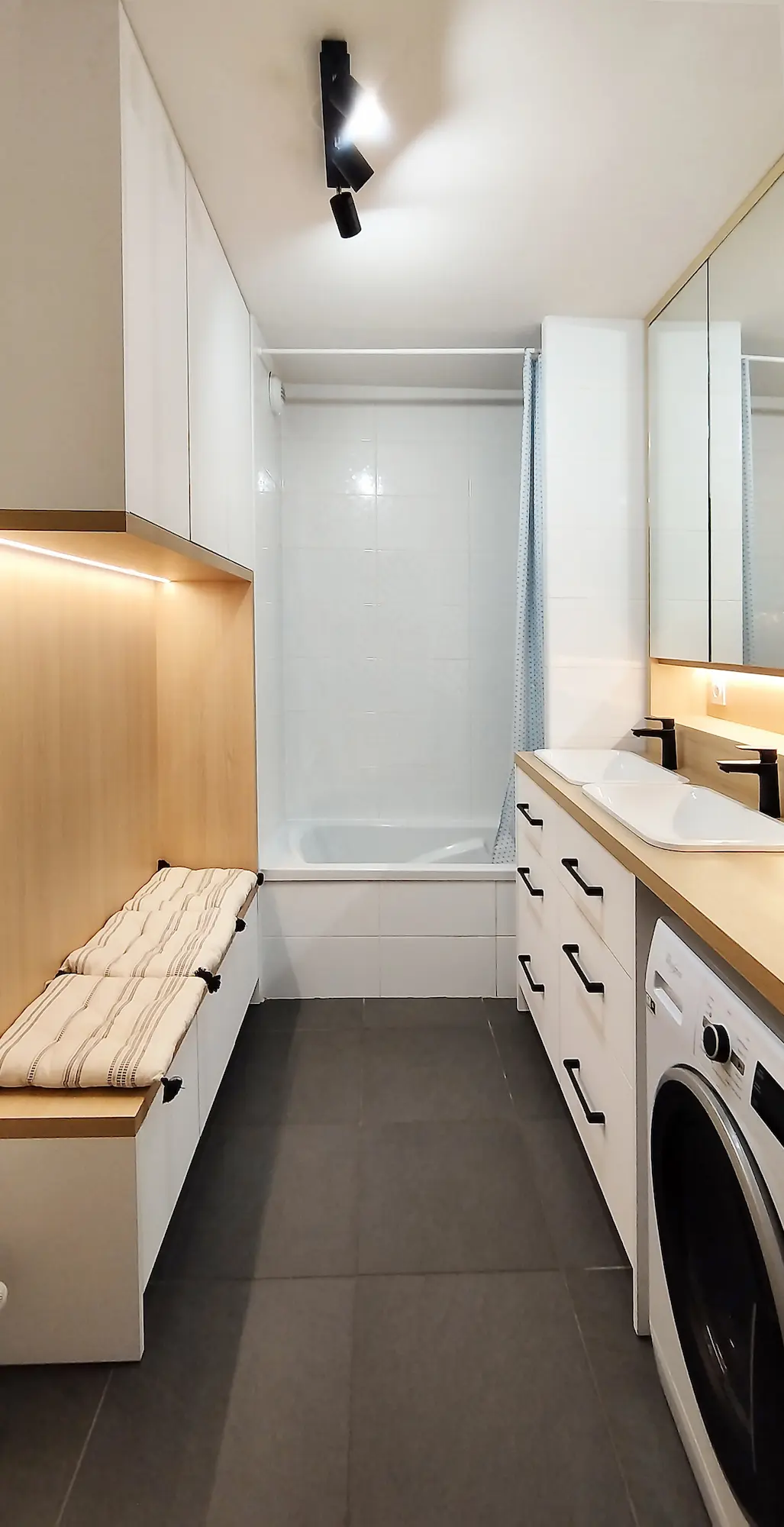 Vue d’ensemble d’une salle de bain optimisée avec rangements et mobilier sur mesure, projet de l’agence Jiwa.a.