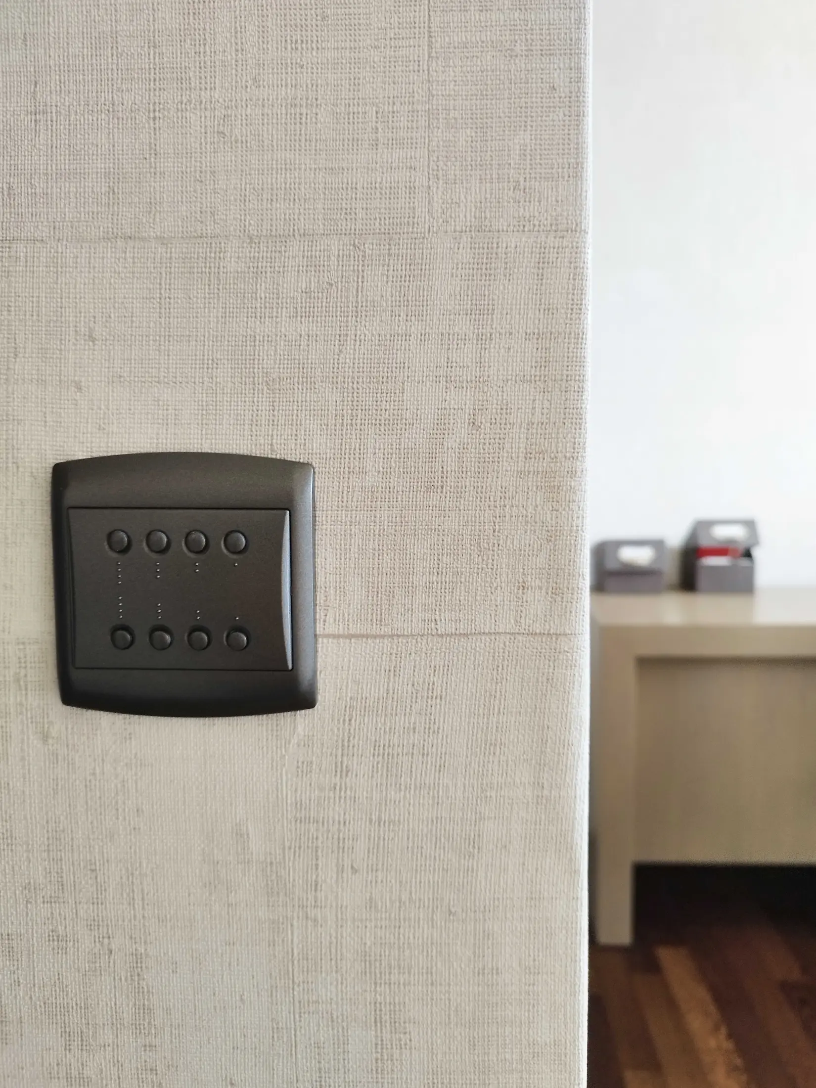 Détail d’interrupteur intégré dans un mur texturé clair, illustration du soin apporté aux finitions.