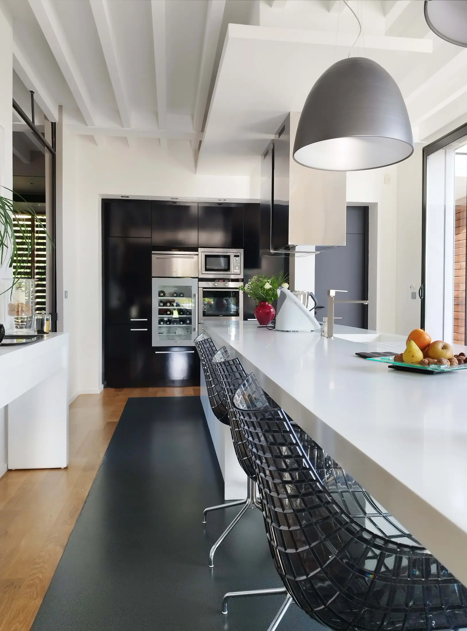 Cuisine contemporaine avec îlot central blanc et suspensions graphiques.