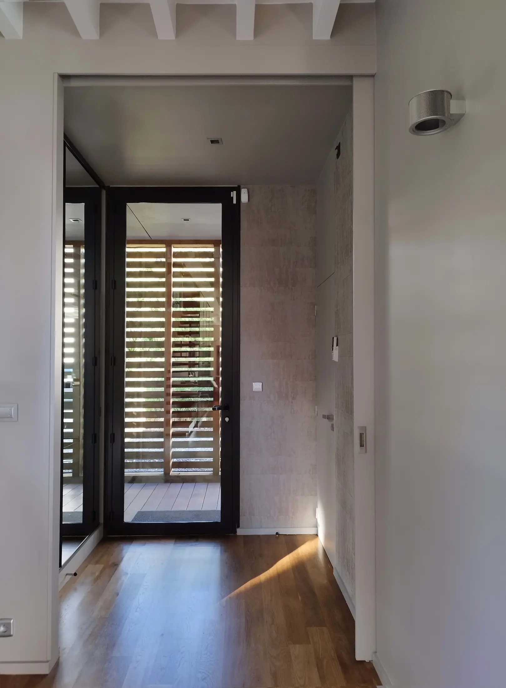Couloir d’entrée moderne baigné de lumière naturelle, aux tons clairs et lignes sobres.