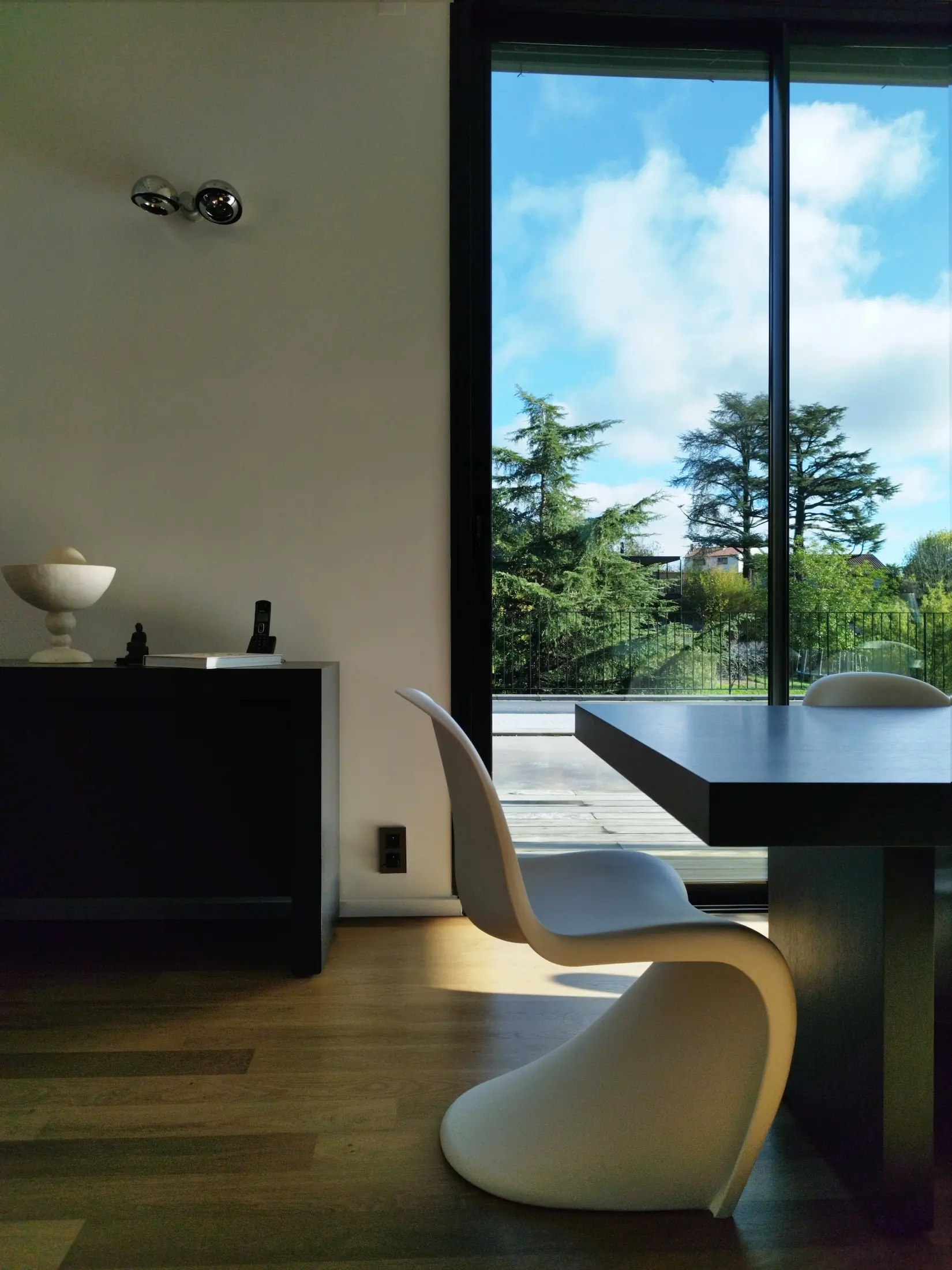 Salle à manger contemporaine avec vue sur le jardin et lumière naturelle abondante.