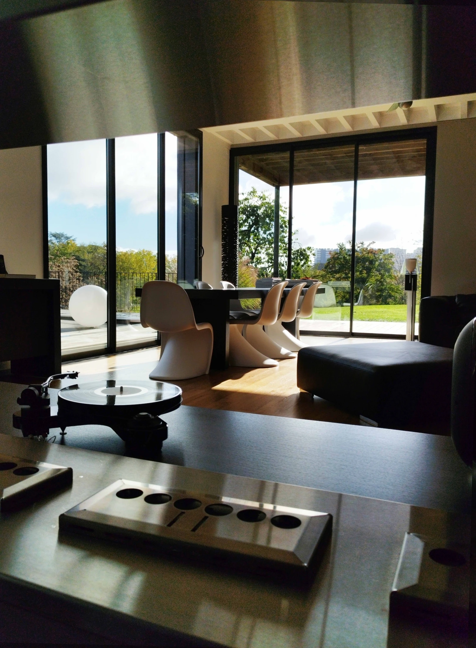 Salon et salle à manger ouverts sur l’extérieur, baignés de lumière naturelle.