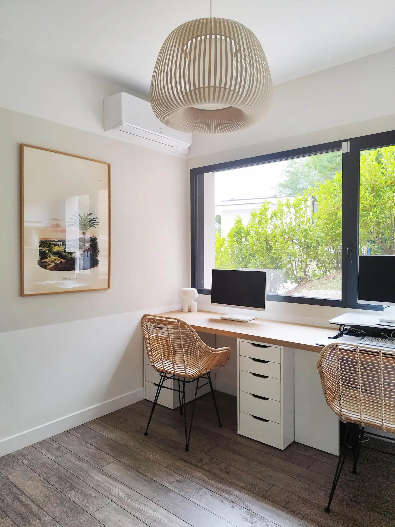 Coin bureau épuré baigné de lumière naturelle, ouvert sur un jardin arboré.