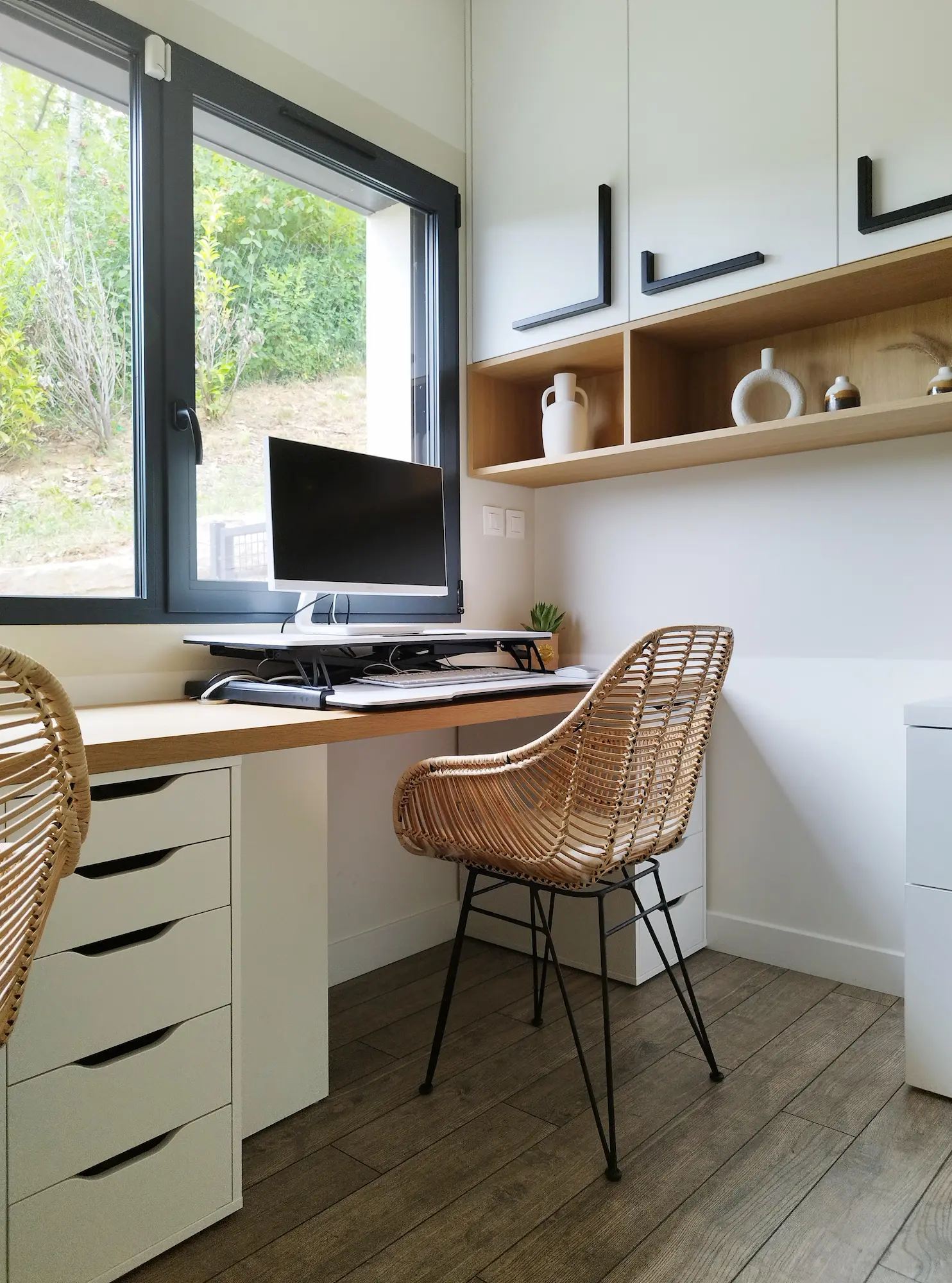 Espace de travail chaleureux associant plateau en bois, chaise tressée et fenêtre gris anthracite