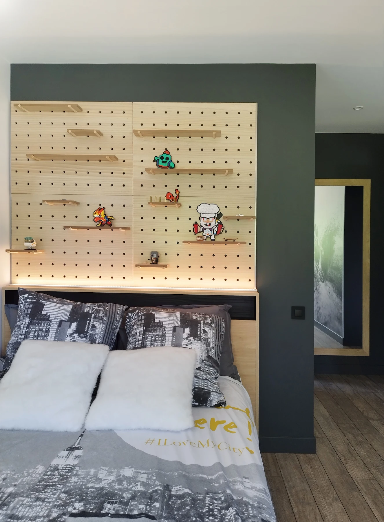 Tête de lit personnalisée en tasseaux de bois, éclairée par un bandeau LED pour une ambiance douce.