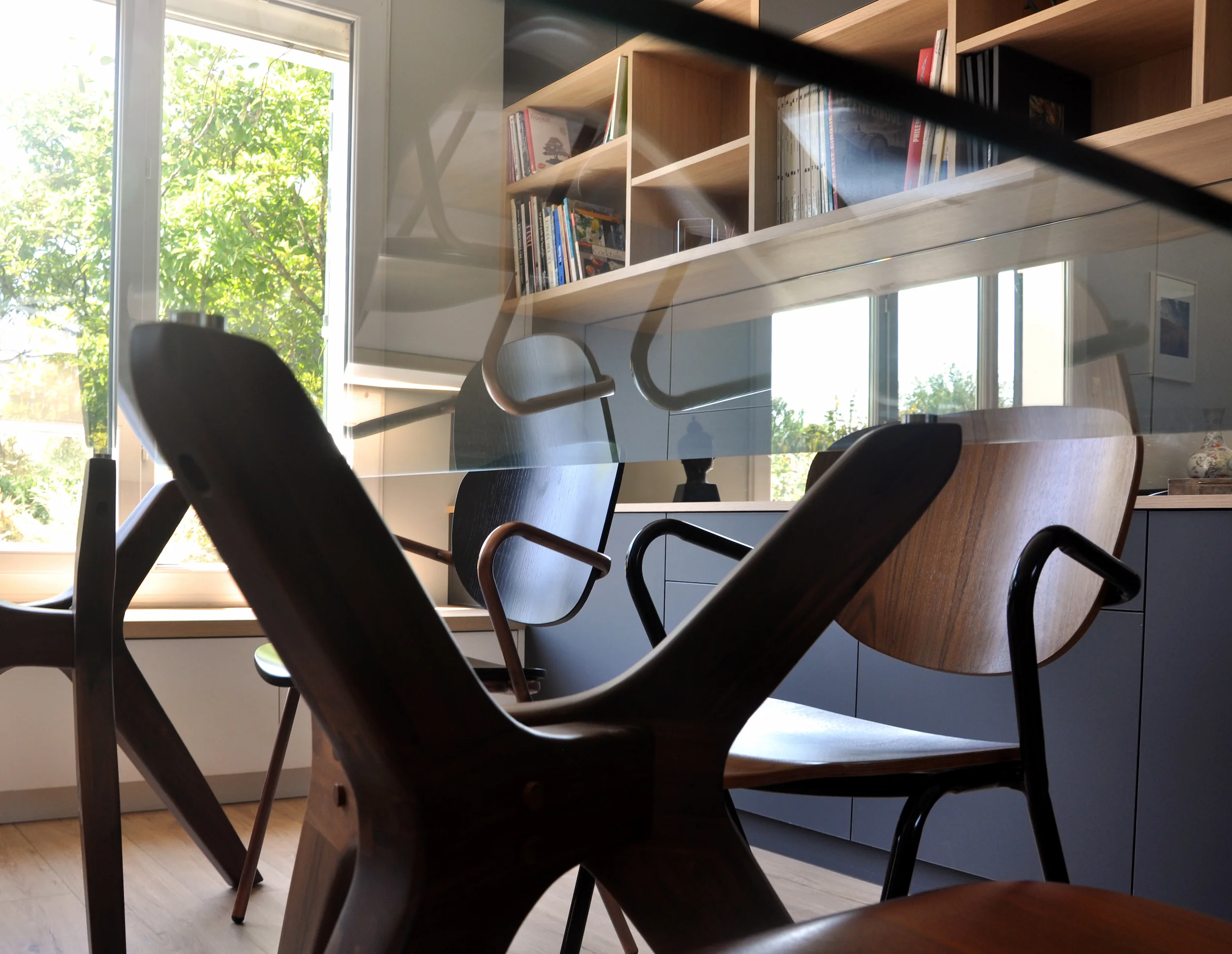 Vue latérale du mobilier sur mesure structurant l’espace de travail et la zone bibliothèque.