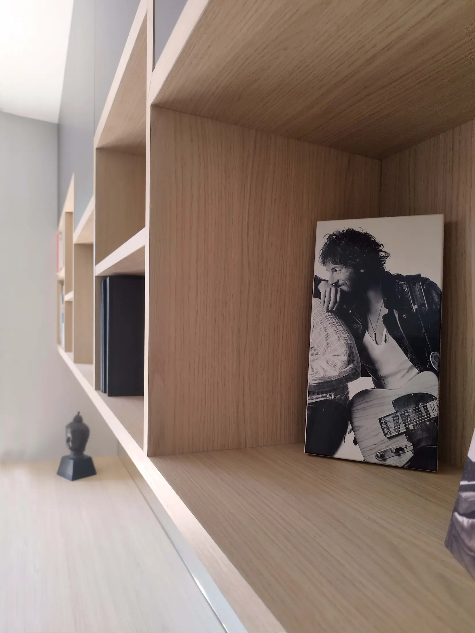 Détail de niche de bibliothèque sur mesure avec objet décoratif, finition bois clair.