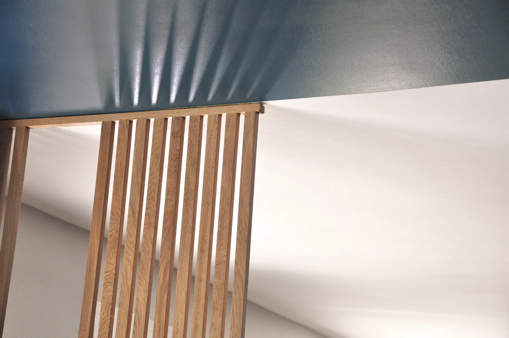 Détail du claustra en bois apportant rythme et séparation visuelle.