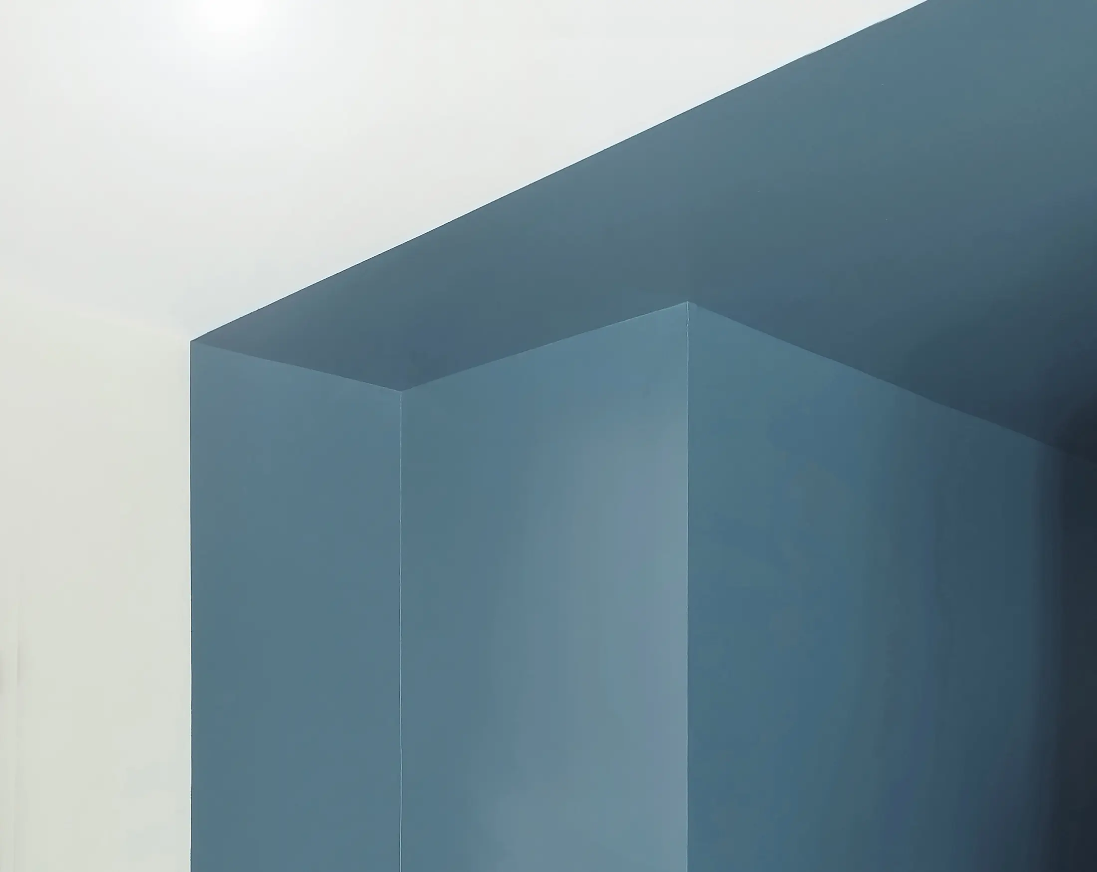 Détail d’angle peint en bleu, apportant profondeur et contraste dans l’aménagement intérieur.