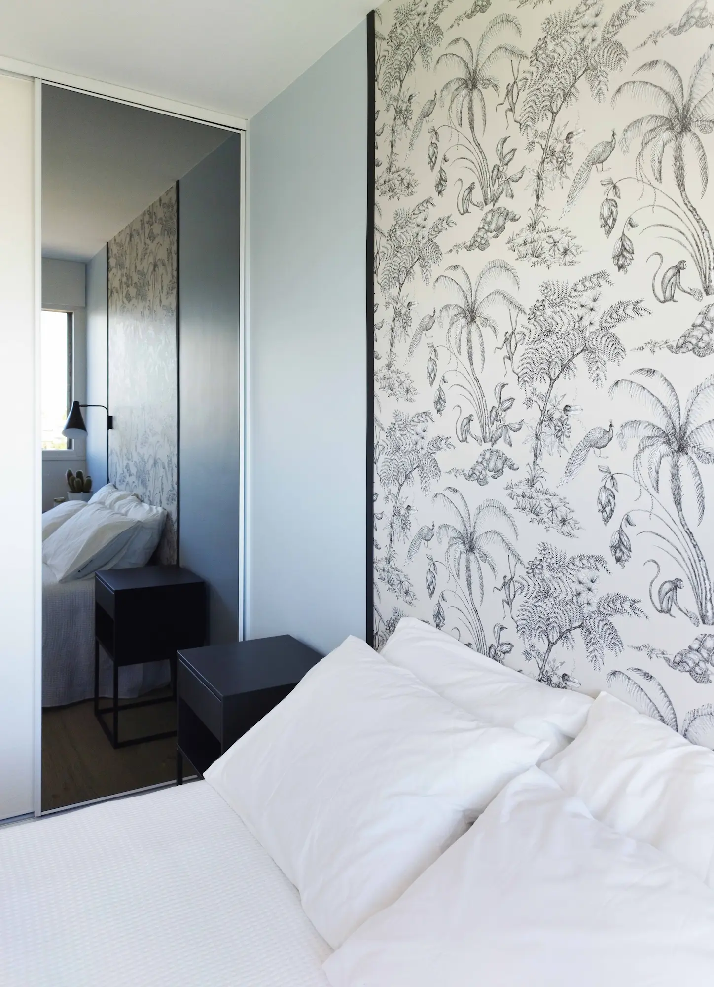  Chambre modernisée avec jeux de reflets et tête de lit encadrée, intégrée dans le projet de rénovation globale.