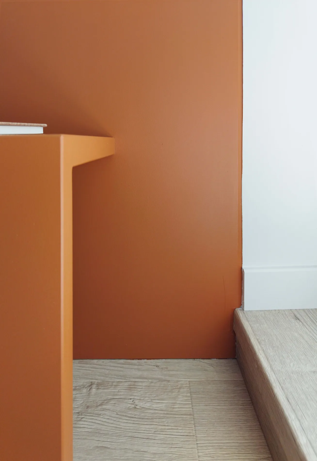 Détail d’un mur terracotta contemporain apportant du caractère à la suite parentale rénovée.