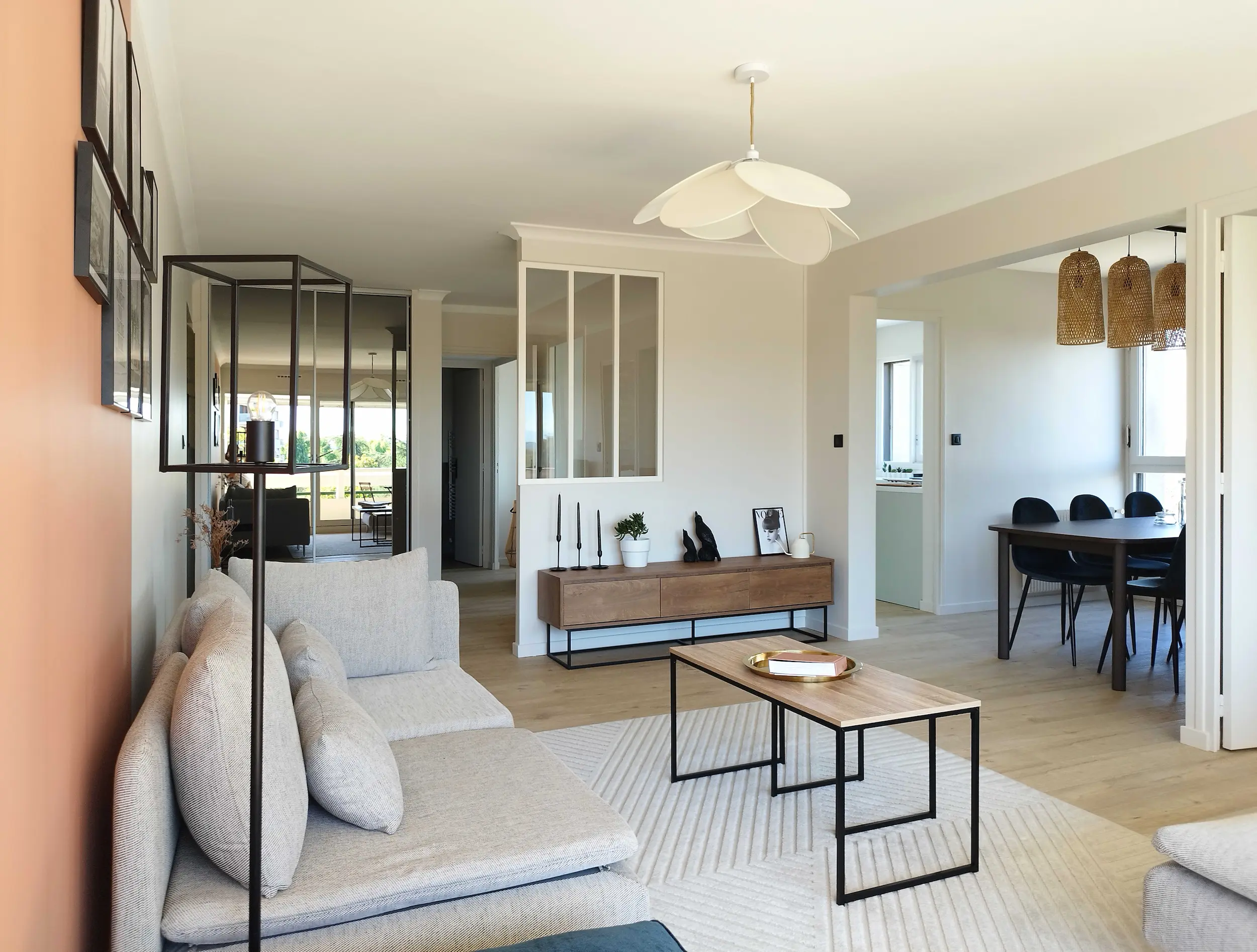 Salon rénové au style contemporain, mêlant teintes douces et mur terracotta, avec mobilier minimaliste et verrière intérieure.