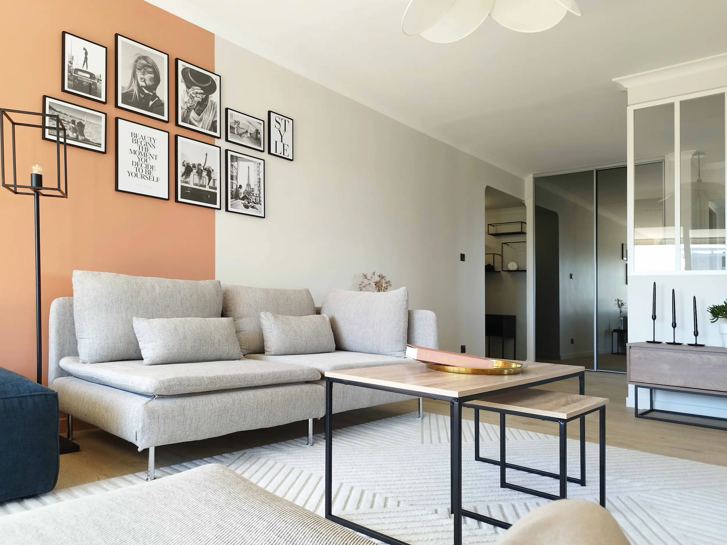 Salon lumineux avec canapé gris, cadres muraux et touches de couleur, dans un appartement rénové des années 80.