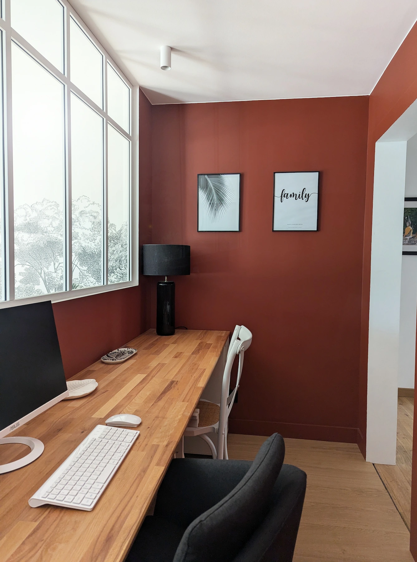 Bureau sur mesure dans un appartement lyonnais, avec plan de travail en bois, murs terracotta et verrière blanche apportant la lumière naturelle.