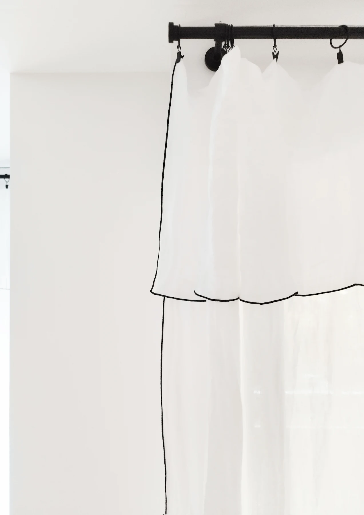 Rideaux blancs légers installés dans un appartement rénové, apportant douceur et luminosité aux espaces de vie.