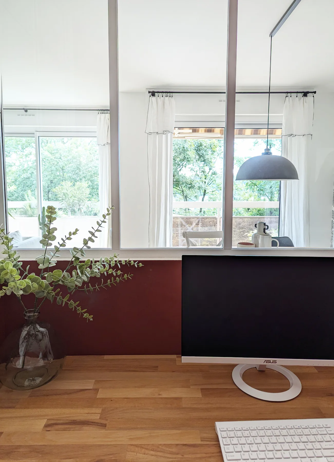 Poste de travail face à la verrière blanche avec vue sur la pièce de vie, dans un appartement réhabilité par l’agence Jiwa.a à Lyon.
