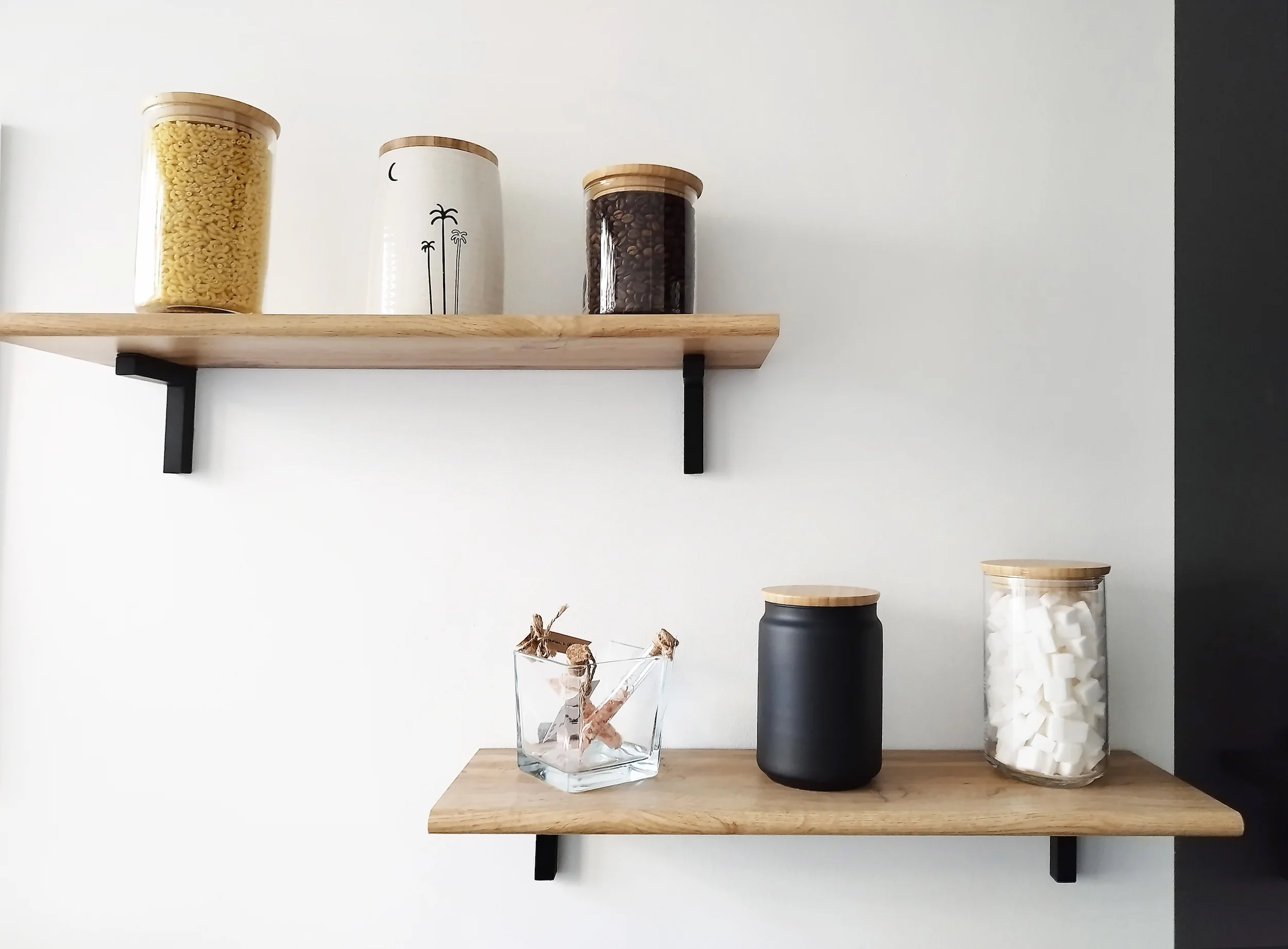 Étagères murales en bois avec objets décoratifs, apportant une touche minimaliste et chaleureuse à l’espace de vie.