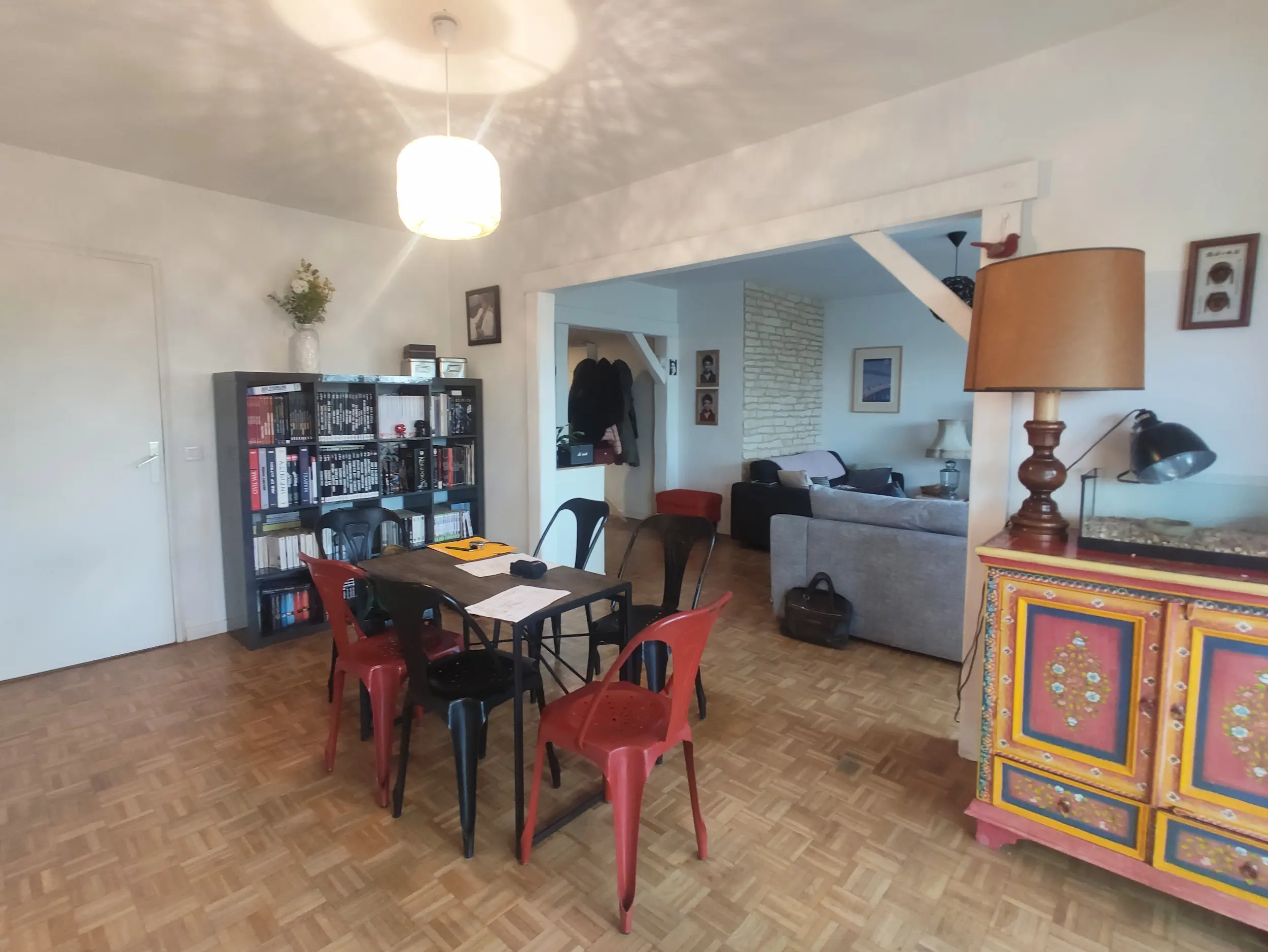 Salle à manger avant rénovation avec sol en parquet, meubles anciens et volumes ouverts, état existant avant réhabilitation.