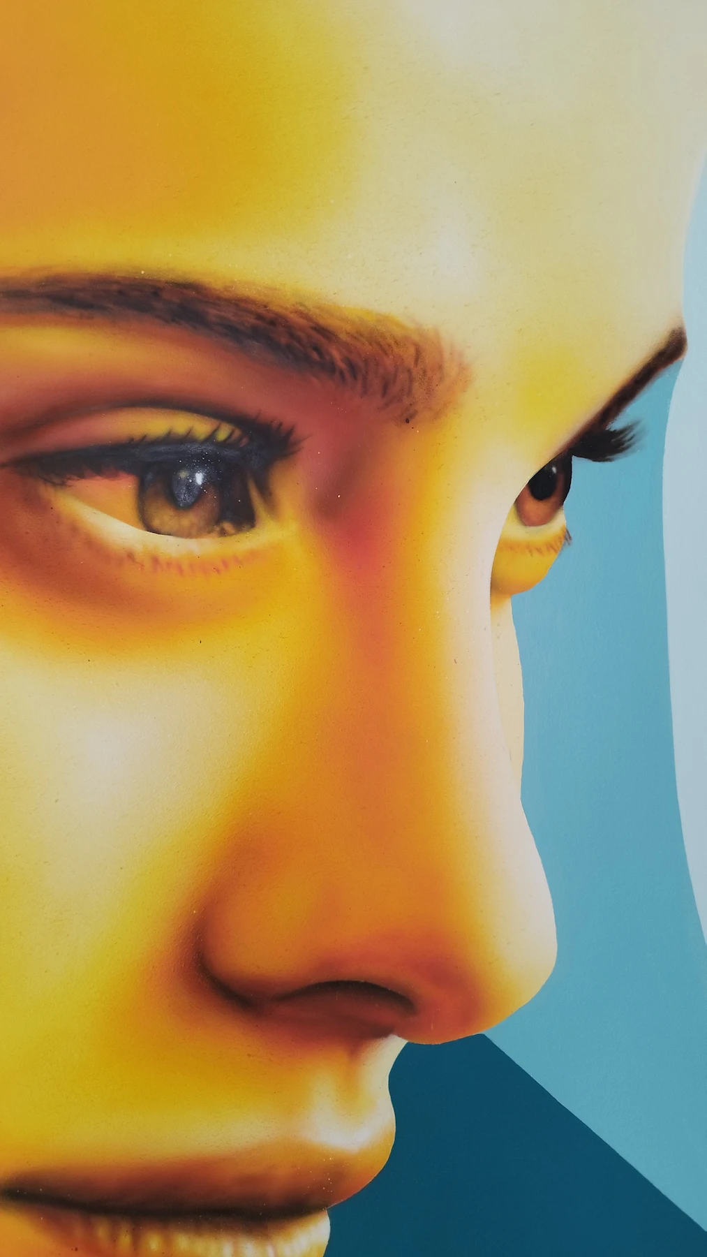 Détail d’une peinture murale graphique représentant un visage stylisé, réalisée à Villeurbanne.