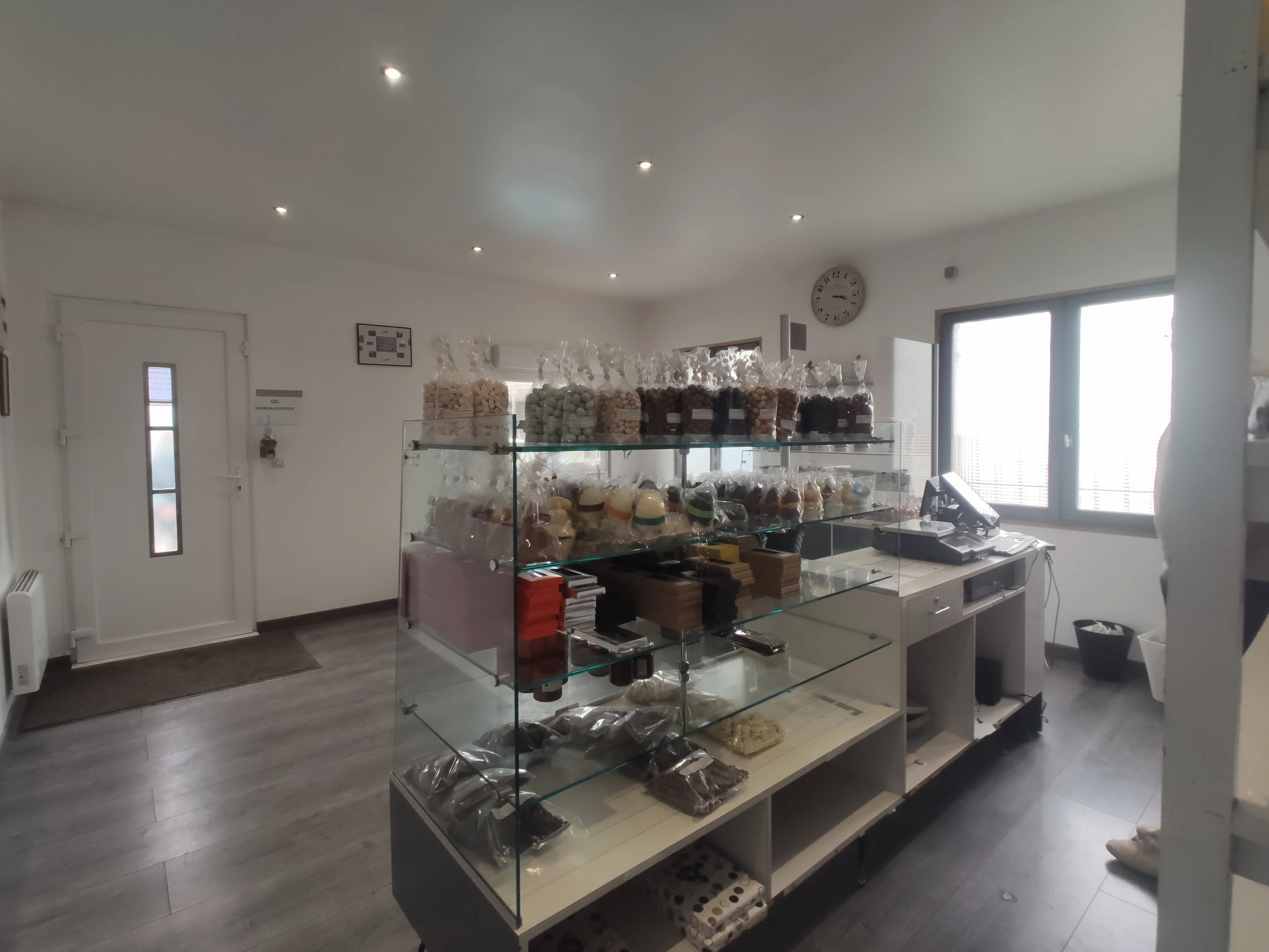 Zone centrale de la chocolaterie avant réaménagement, vitrines et sol existants.