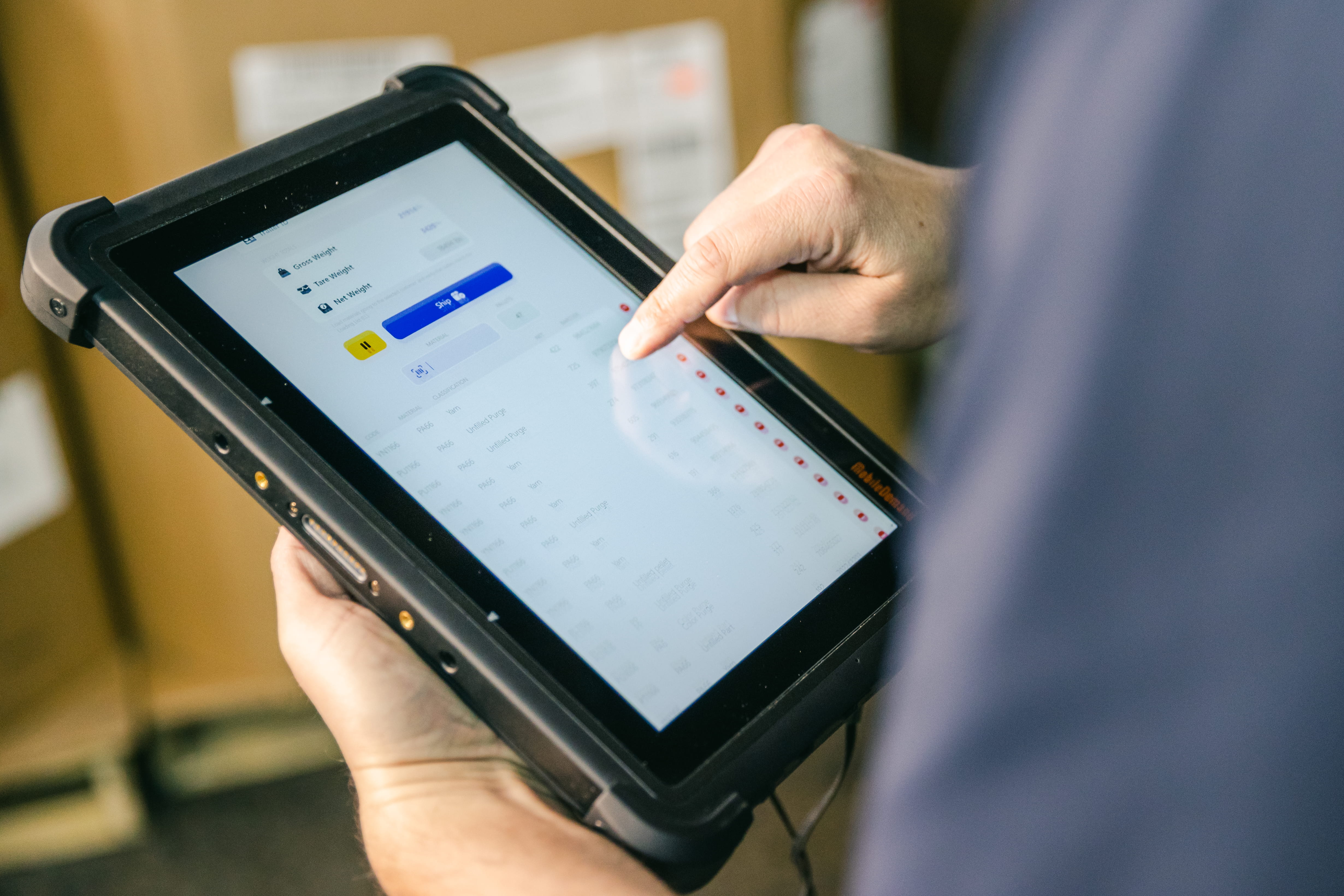 Shop-floor manager holding a smart device, inspecting the production line.   