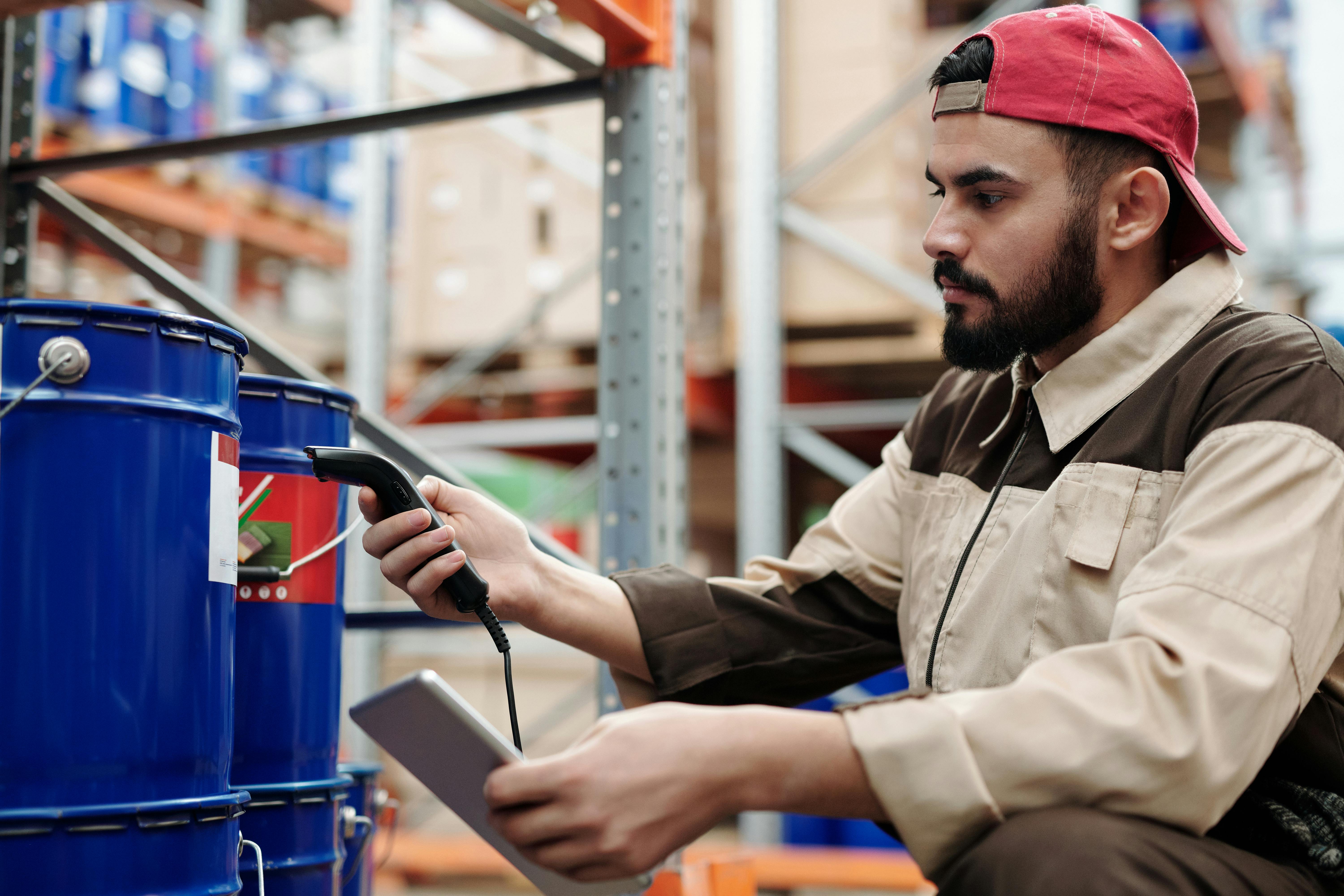 A busy distribution center with workers moving boxes and scanning inventory in the background.
