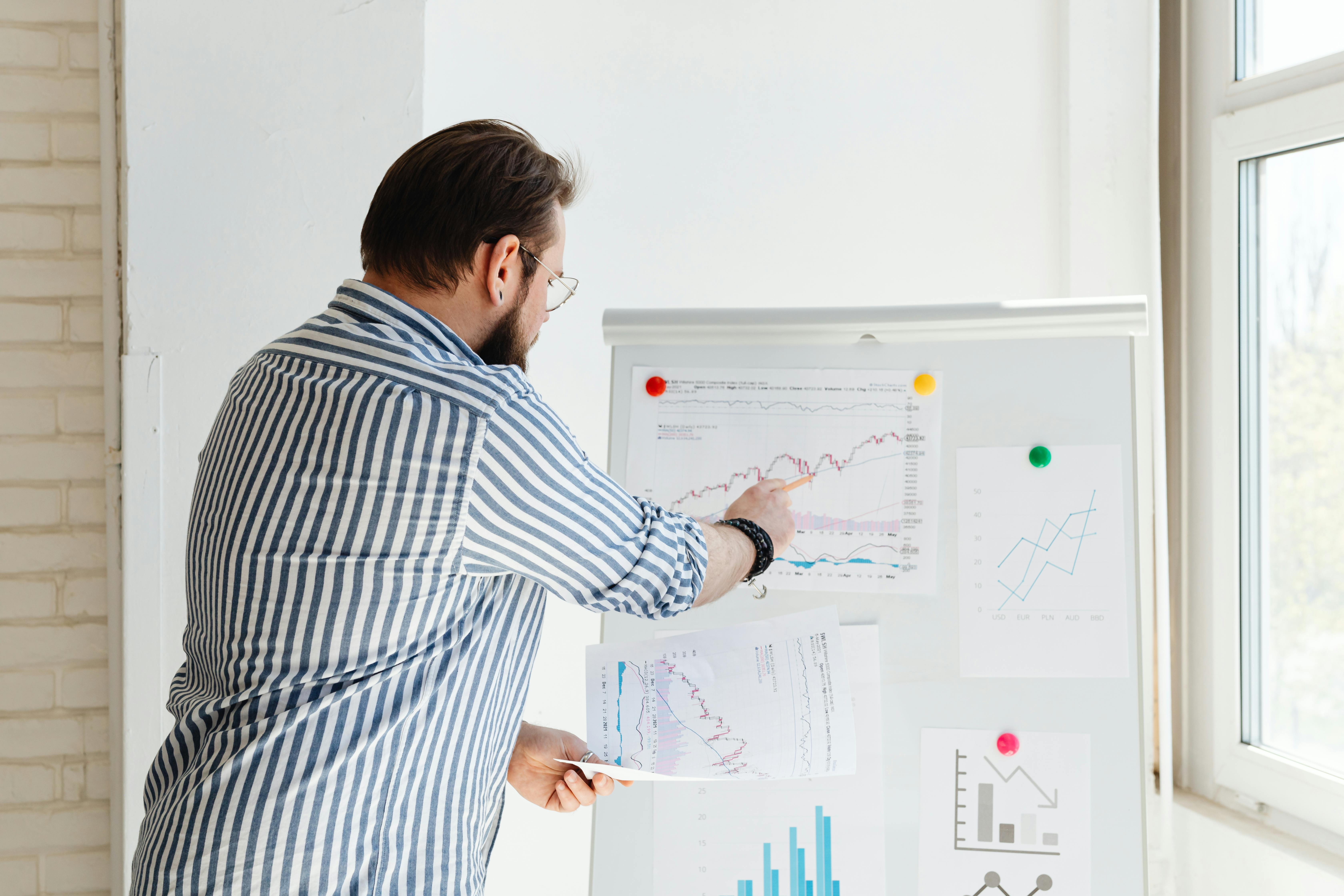 Warehouse operations manager pointing at a whiteboard during a team meeting.