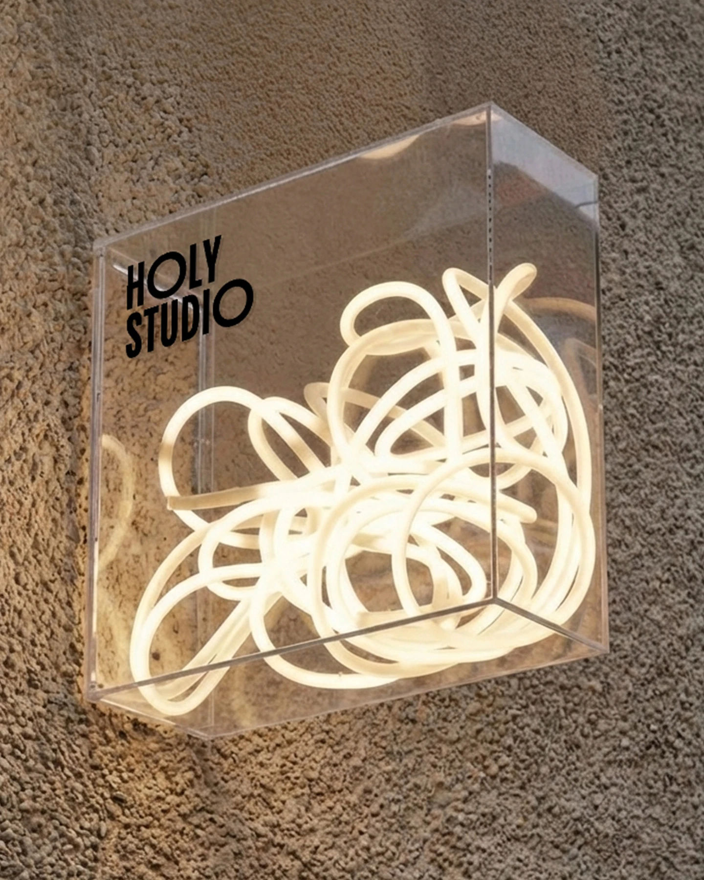 Kobieta w beżowym topie i spodenkach trzyma jasną torbę na ramieniu z napisem HOLY STUDIO i HOLY VIBES DAILY ROUTIN w pomarańczowym kolorze.