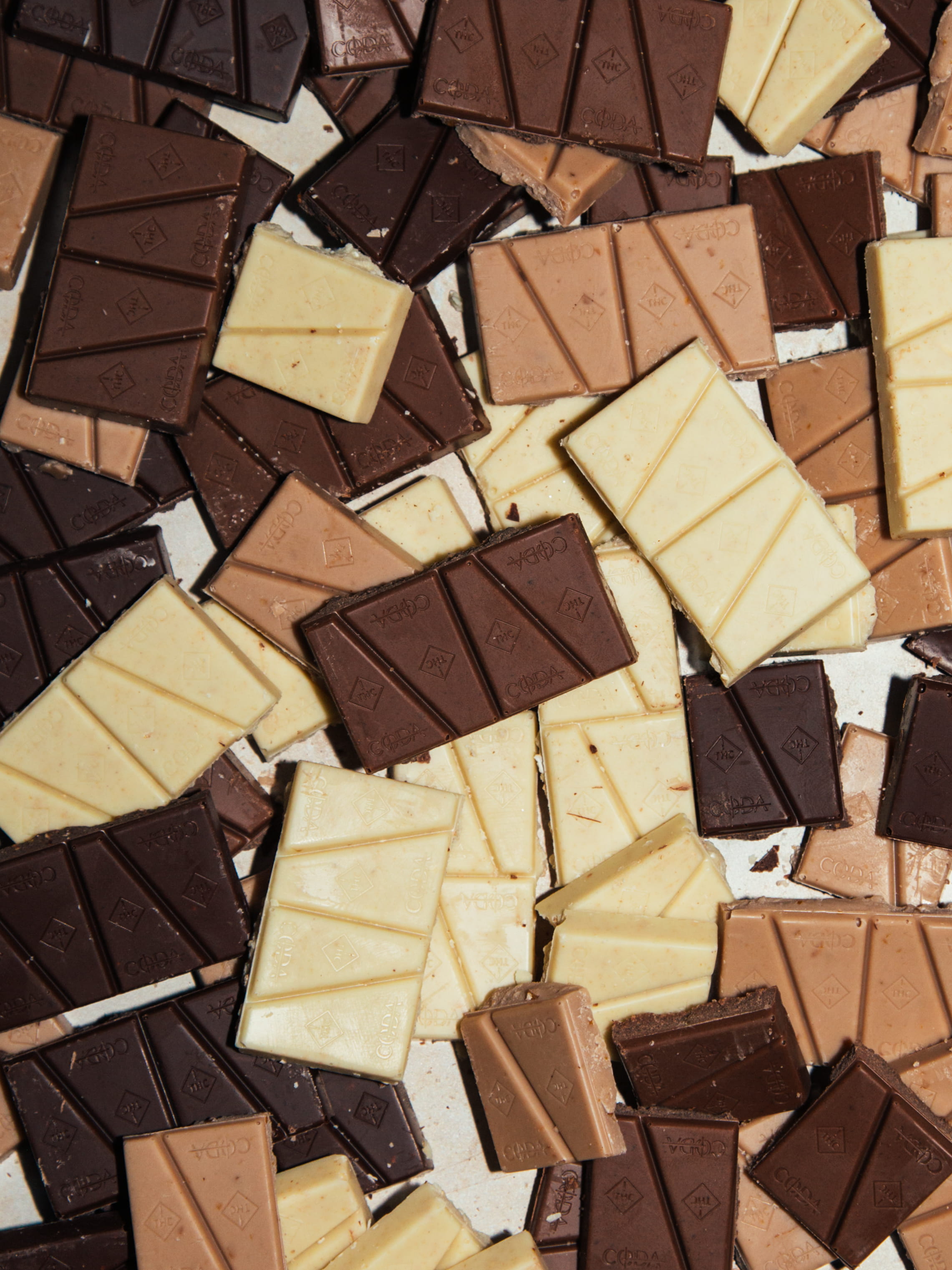 Assorted pieces of dark, milk, and white chocolate scattered on a surface.