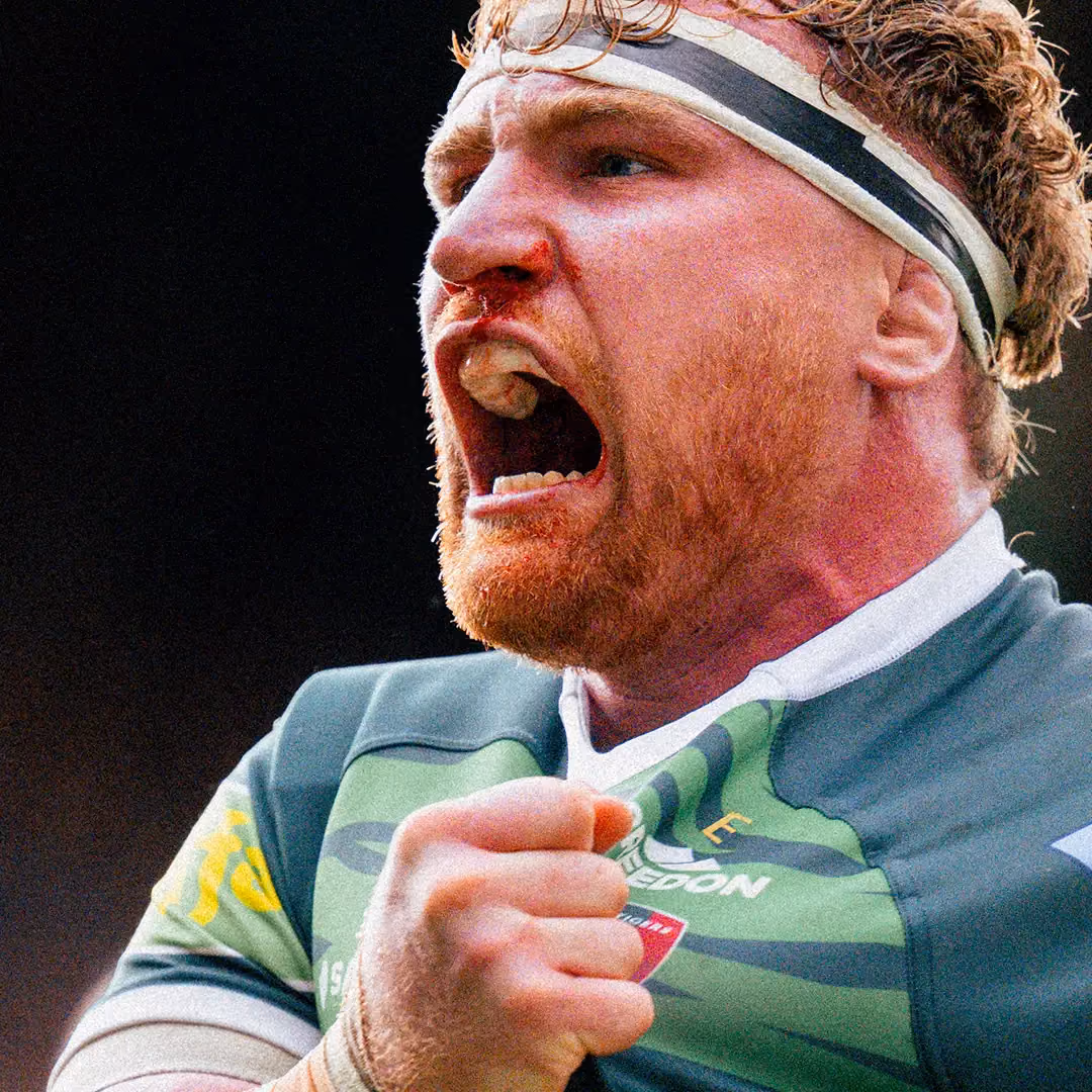 Rugby player with a bloody nose shouting with clenched fist on his chest during a game.
