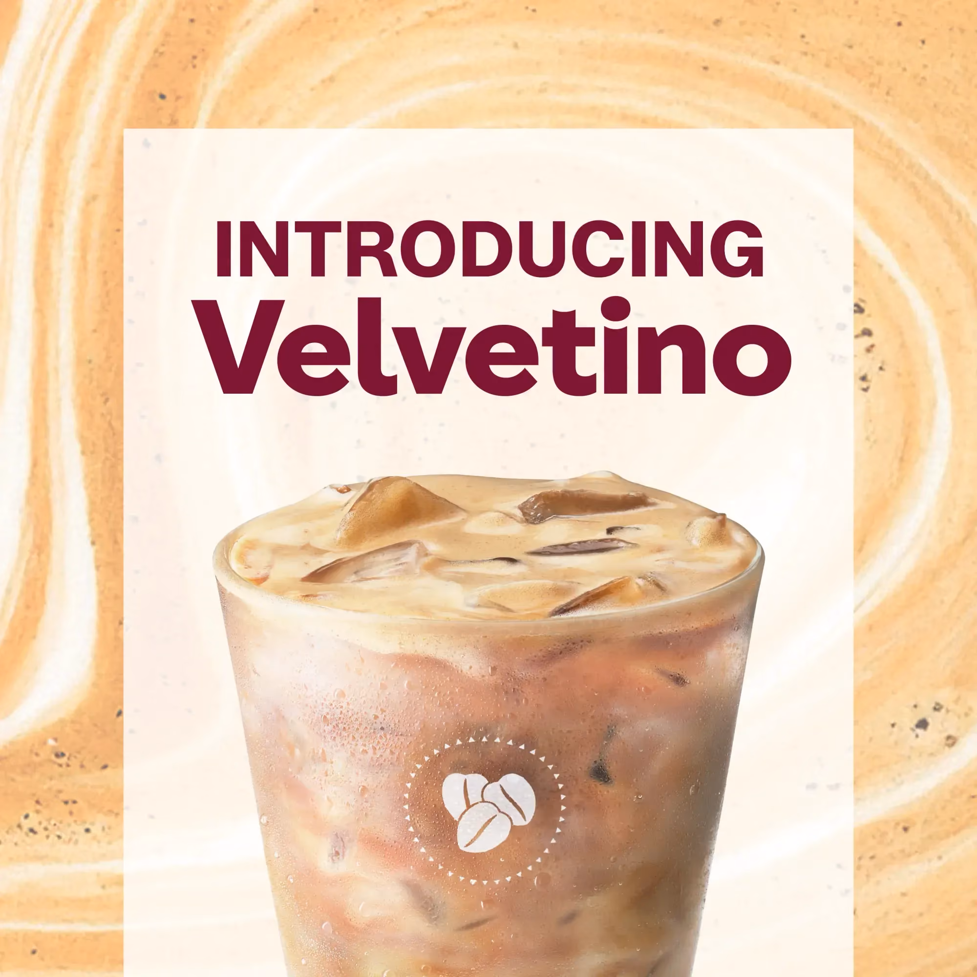 Iced coffee drink named Velvetino with creamy layers and coffee bean icon on cup.
