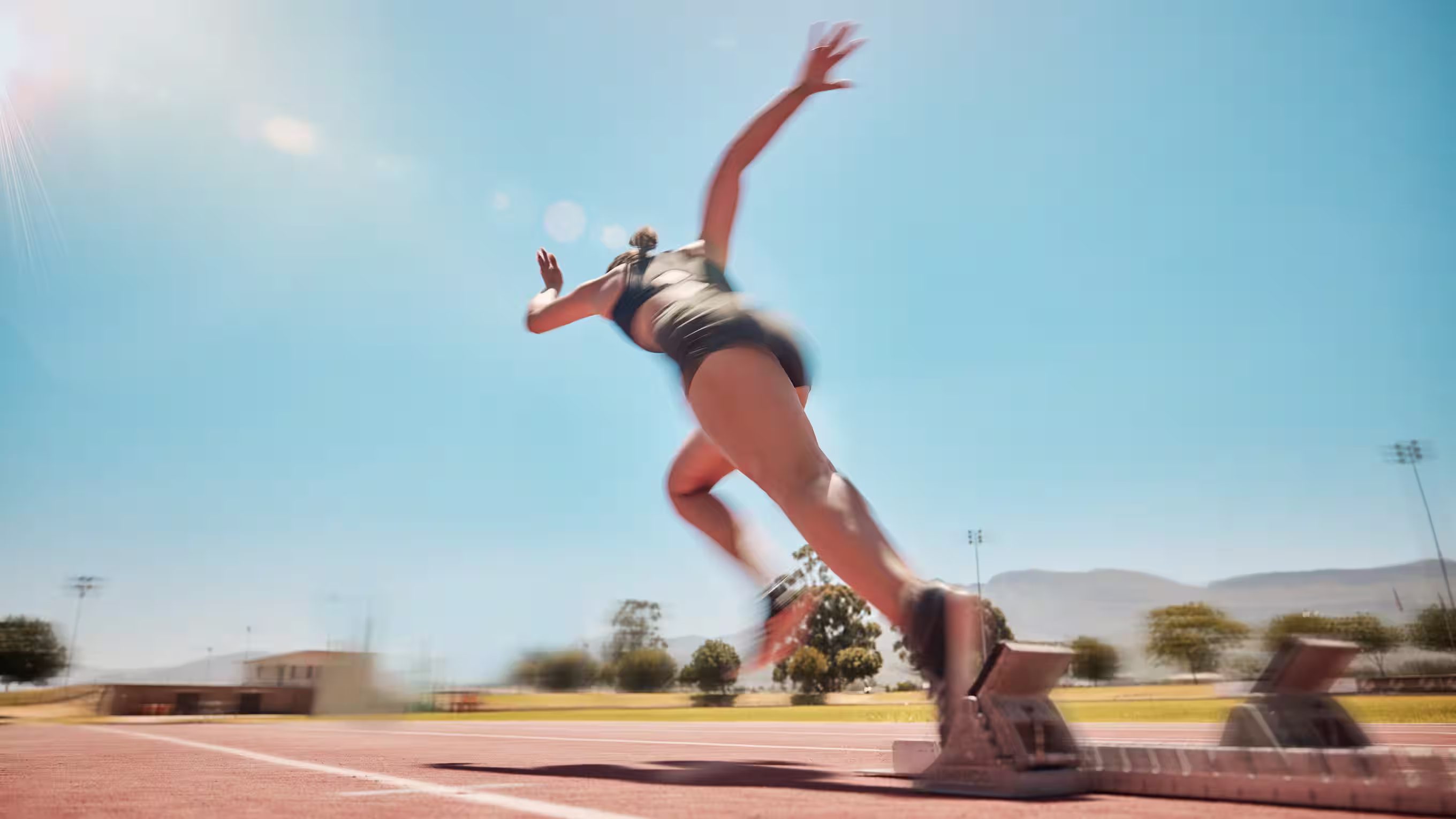 A runner jumping off the starter blocks 