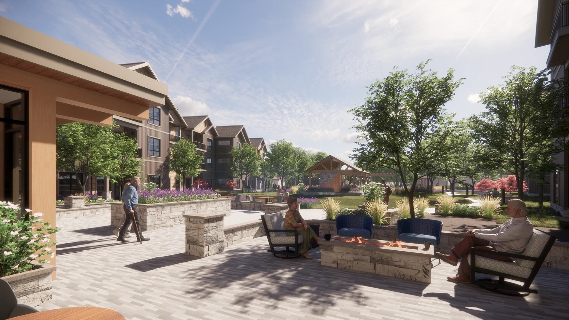 Sunny courtyard with seating around a fire pit, people sitting and walking, surrounded by trees and multi-story residential buildings.