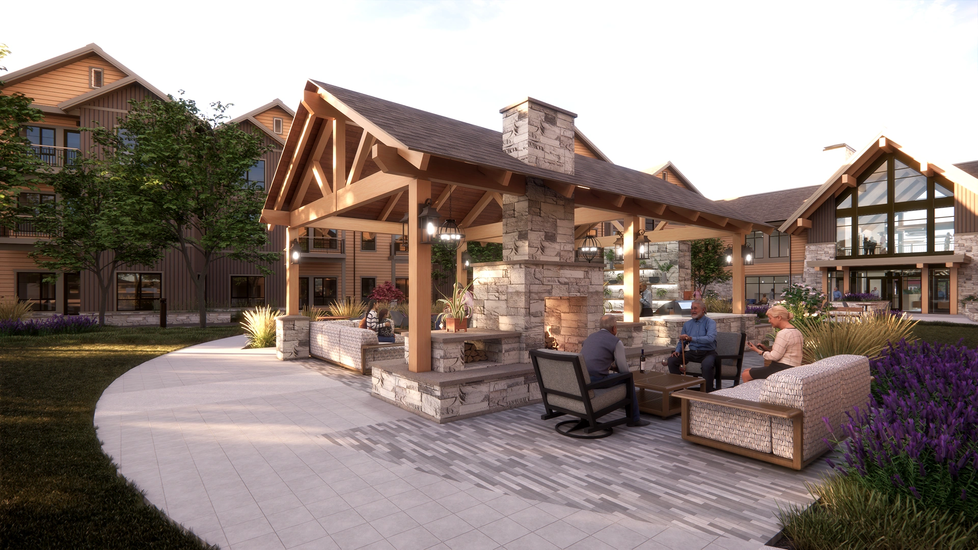 Outdoor pavilion with stone fireplace and wooden beams, surrounded by comfortable seating and people relaxing in a landscaped courtyard.