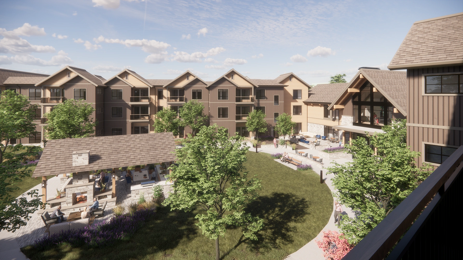 Spacious courtyard area of a residential complex with green lawn, trees, outdoor seating, and a covered fireplace.