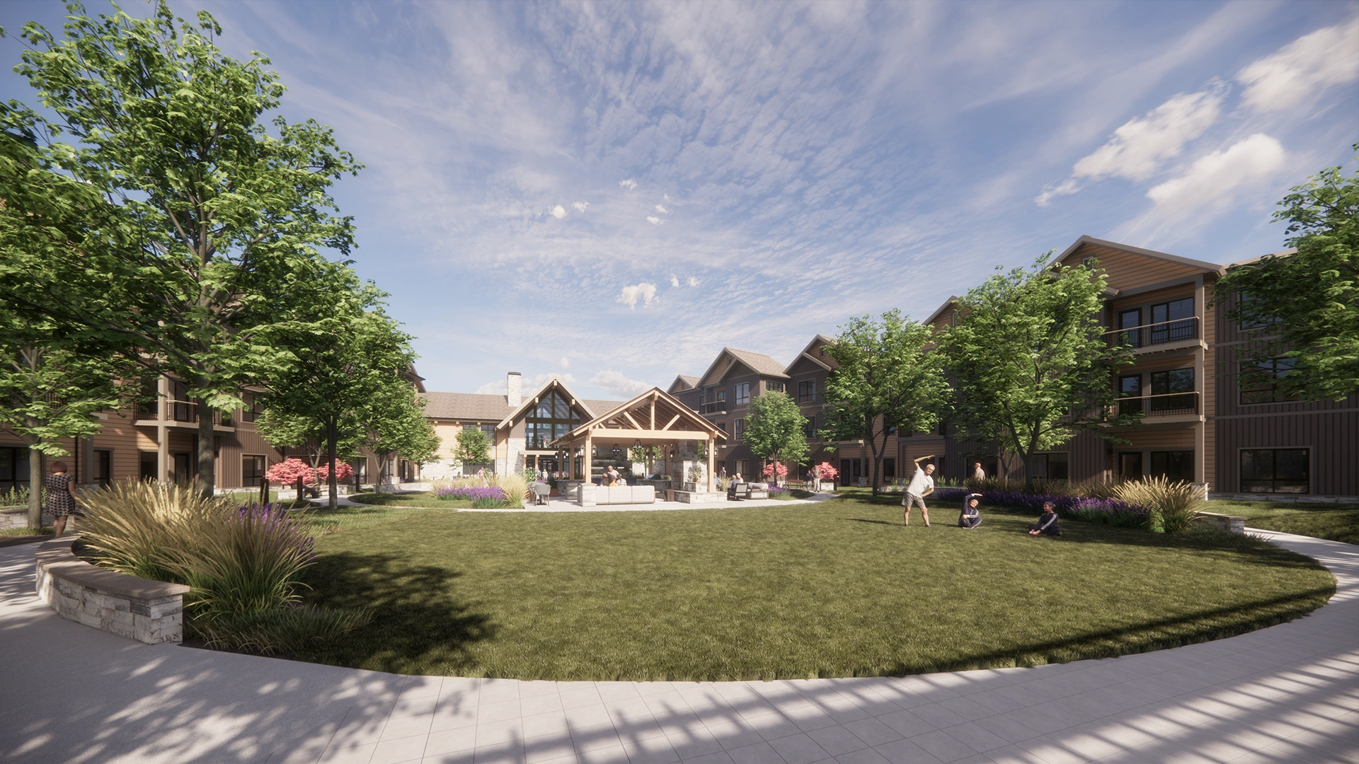 Sanavite Estates courtyard with green lawn, trees, and seating area under a pavilion surrounded by modern apartment buildings under a partly cloudy sky.