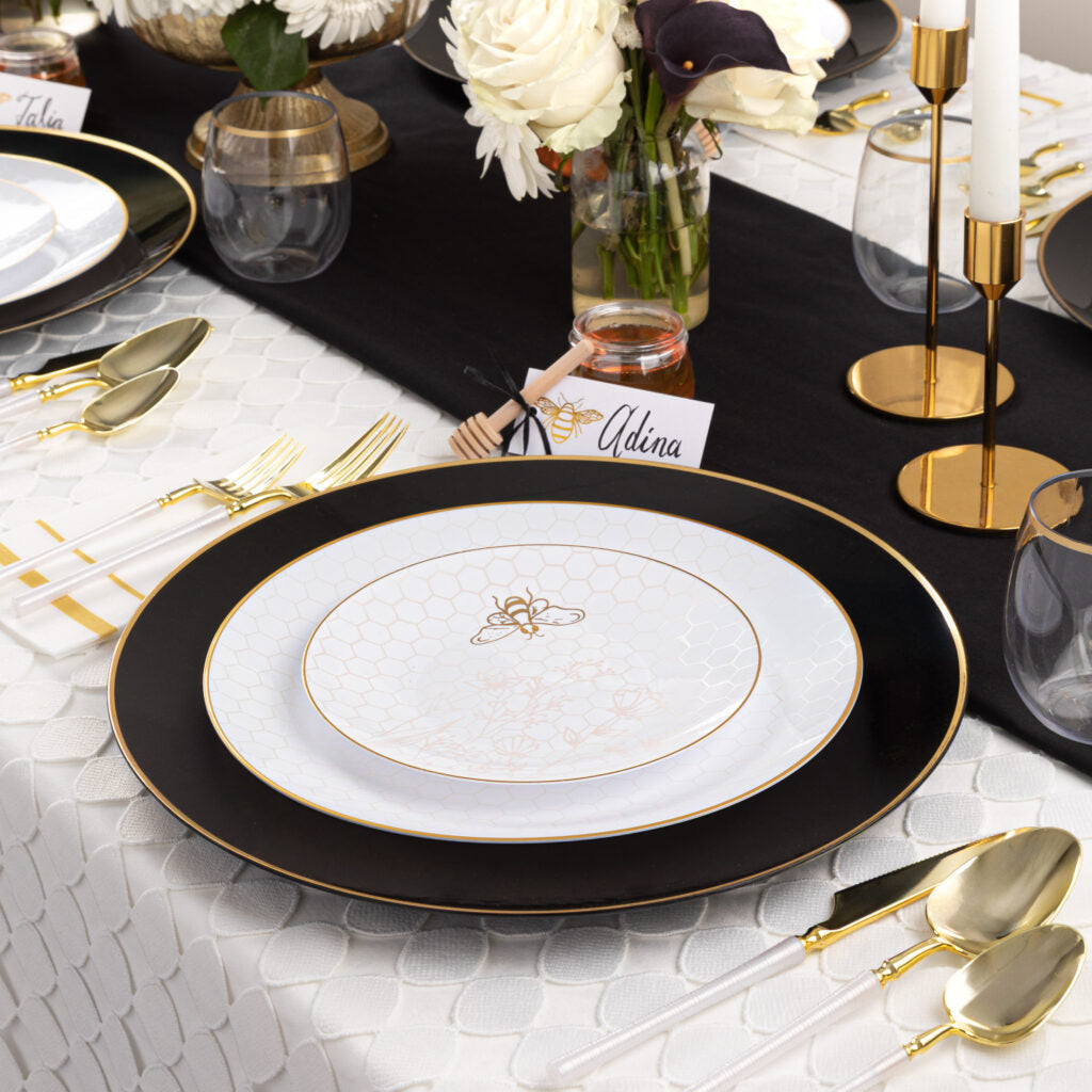 Rosh Hashana table setting with layered plates, gold flatware, flowers and honey